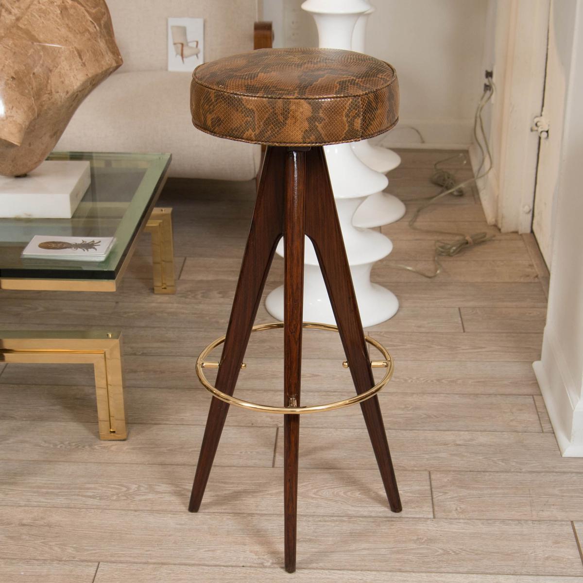 Pair of four-leg wood stools with snake skin upholstered seats and brass details.