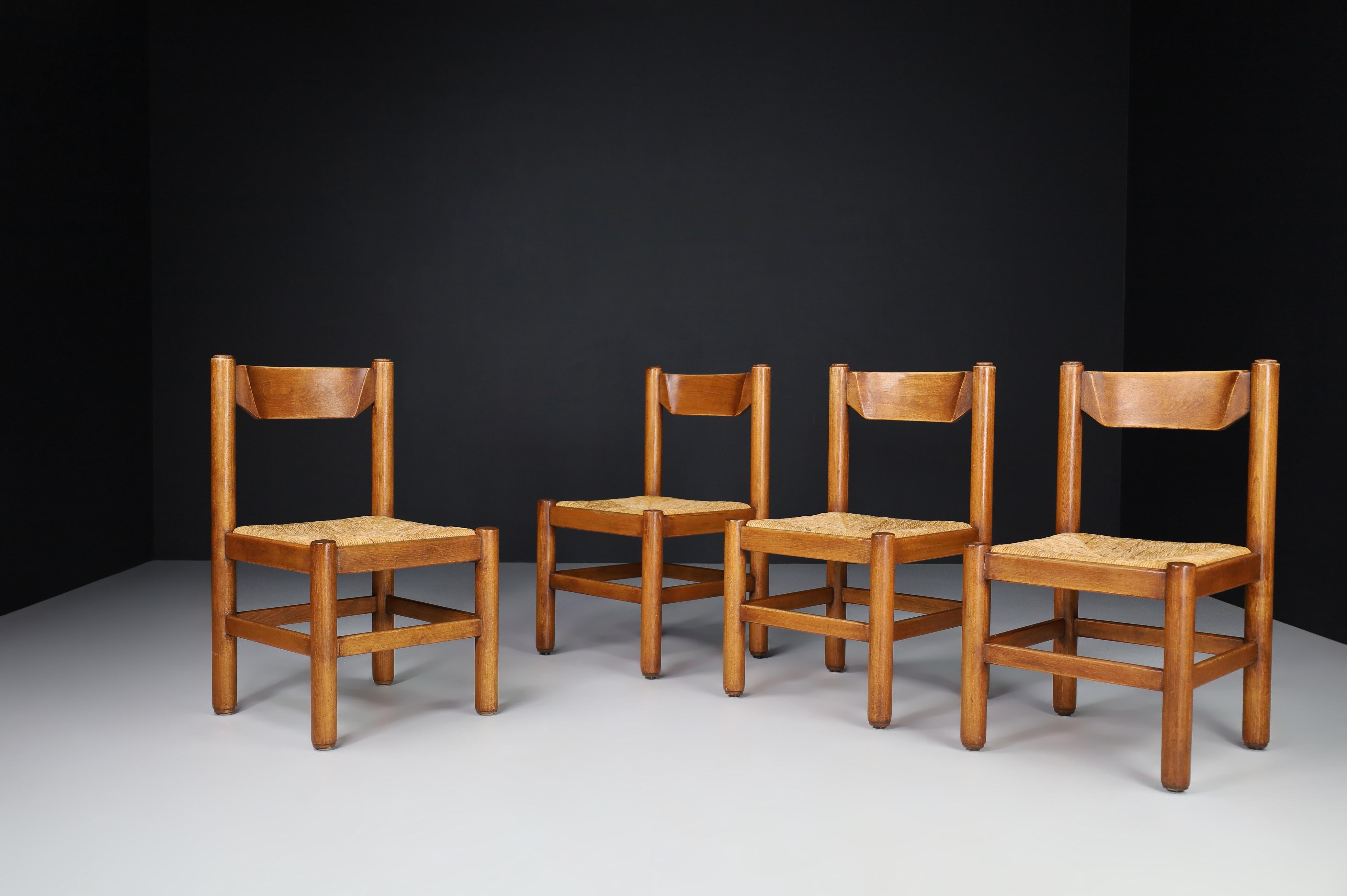 Pair of four oak and rush chairs in the style of Charlotte Perriand, France, 1960s. 

These solid oak chairs show a lovely natural patina and are in excellent original condition. These chairs would be an eye-catching addition to any interior, such
