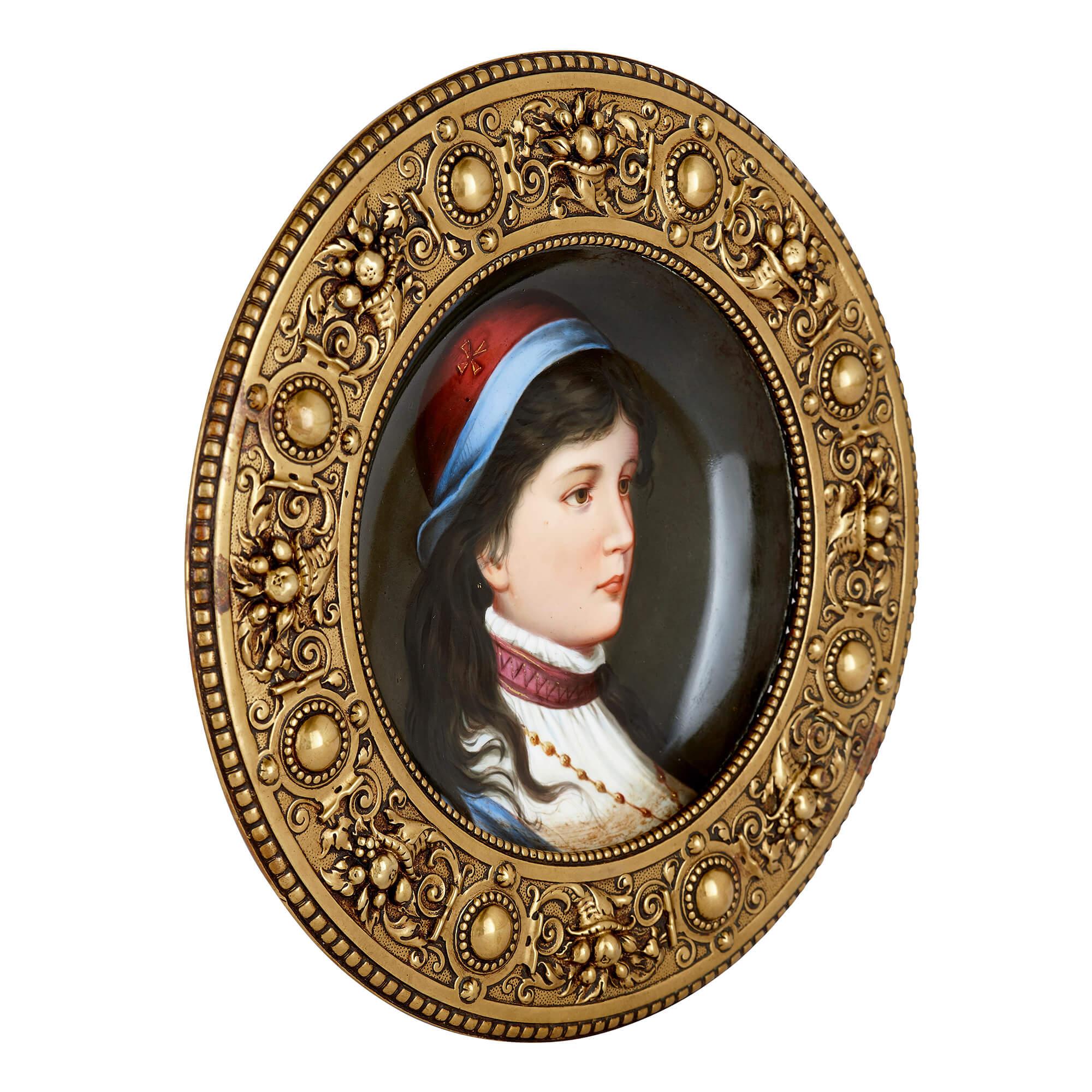 These two porcelain plaques have been expertly painted to show portraits of a young girl and a young boy, and are set within circular brass frames. 

The girl wears a light blue coat and a white shirt, with a maroon-coloured collar, and beaded