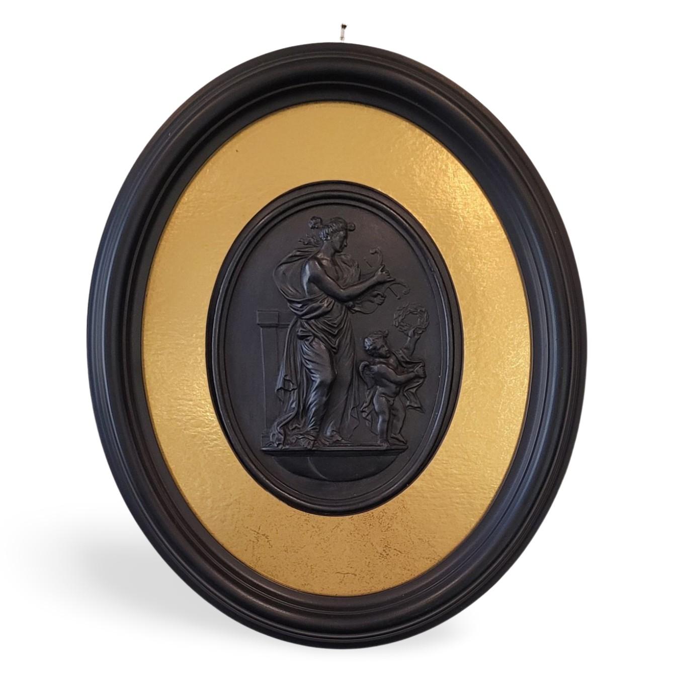 A pair of black basalt medallions, depicting Venus & Cupid, as Day and Night. Day shows Venus and Cupid with symbols of victory; night shows Venus offering poppies, which are symbolic of sleep, as they are the source of opium.

Recently framed, and