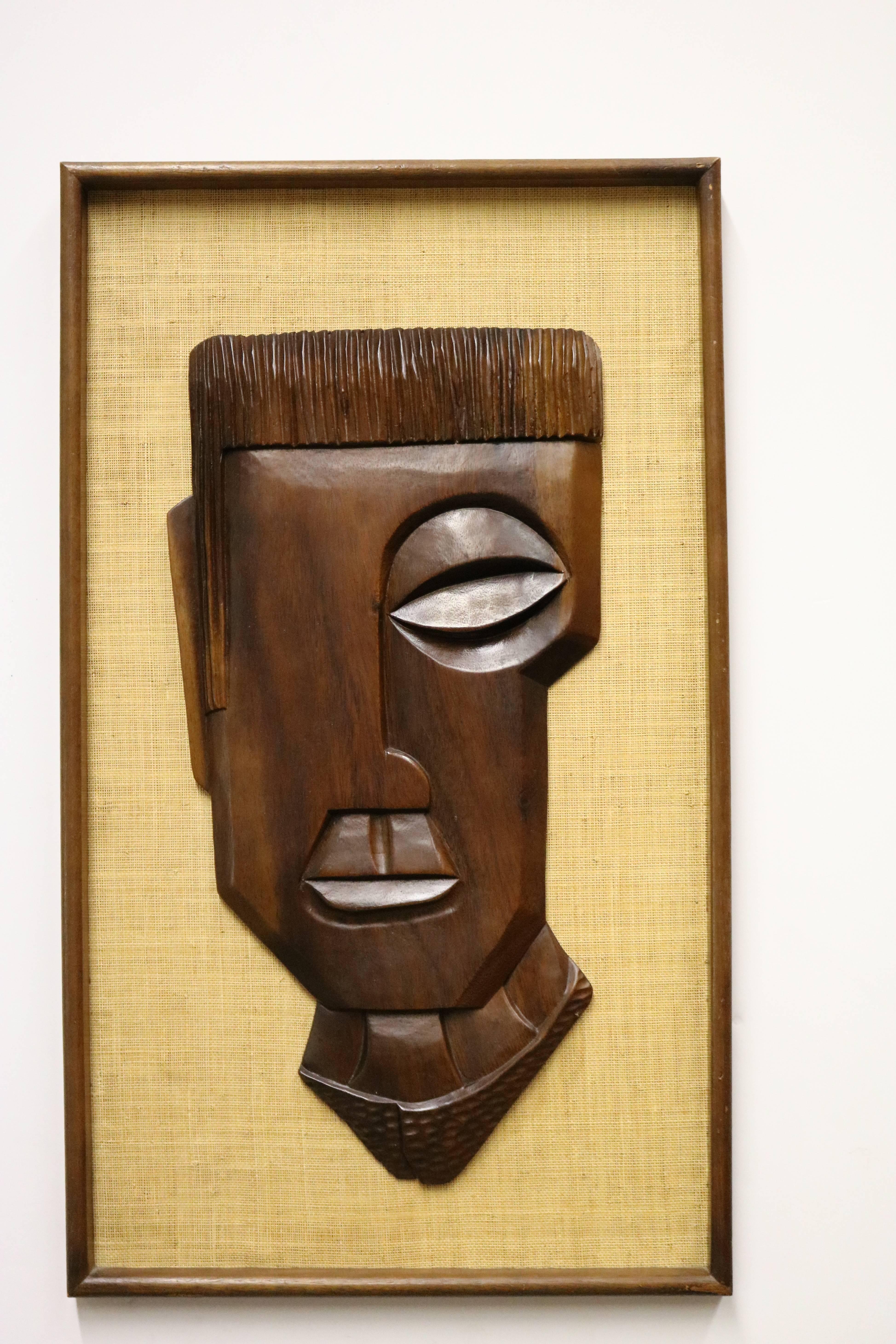 Pair of framed wood carvings of male and female faces mounted on burlap; each is completed flat on the back and secured to the burlap.
Appear to be African in origin but we cannot name an exact region.