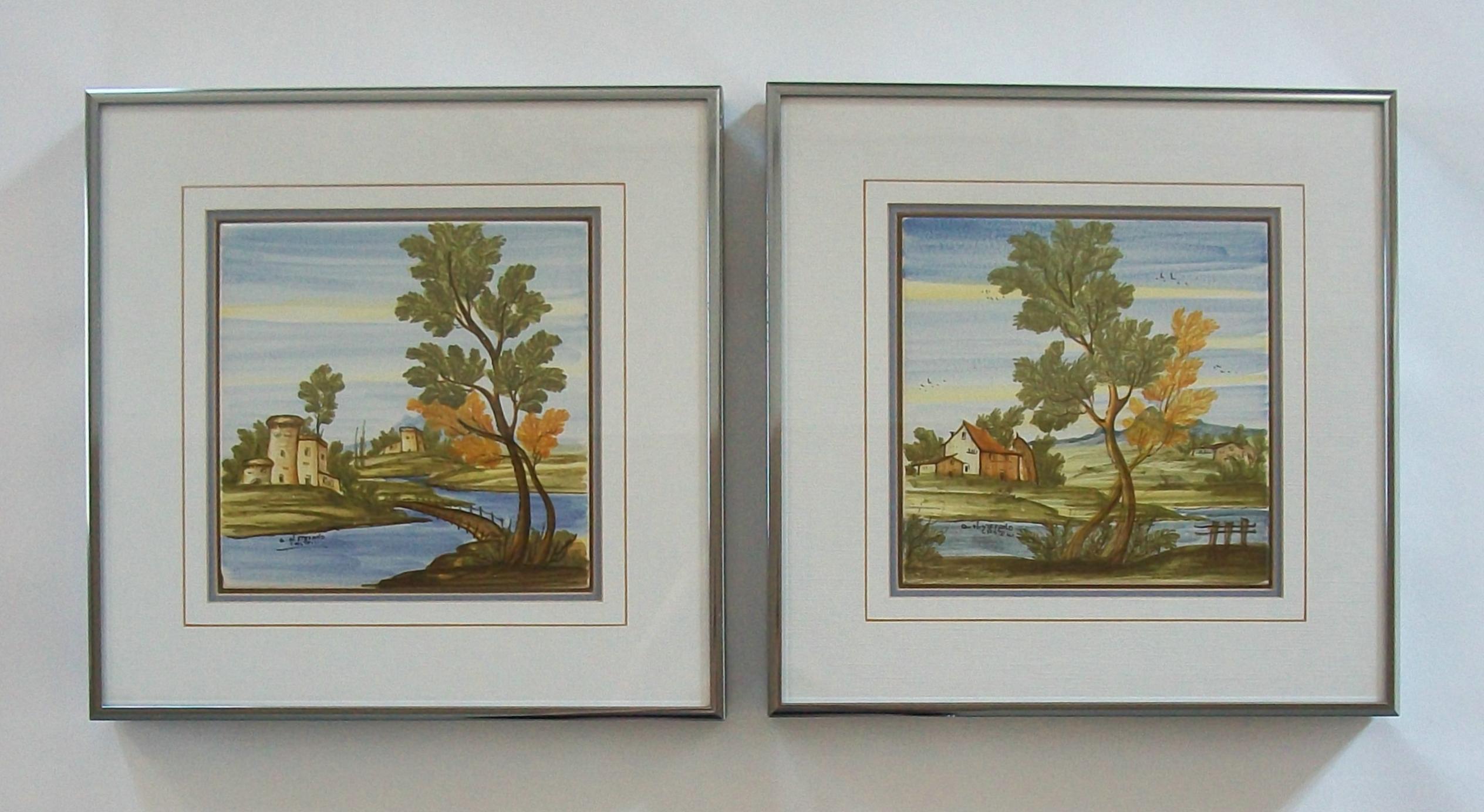 Pair of framed Castelli majolica landscape tiles - medium size - hand painted and glazed in the 18th century style of the region - featuring bucolic landscapes with castles and country houses - each tile signed 'Q. ol. STEFANO, CASTELLI' - vintage