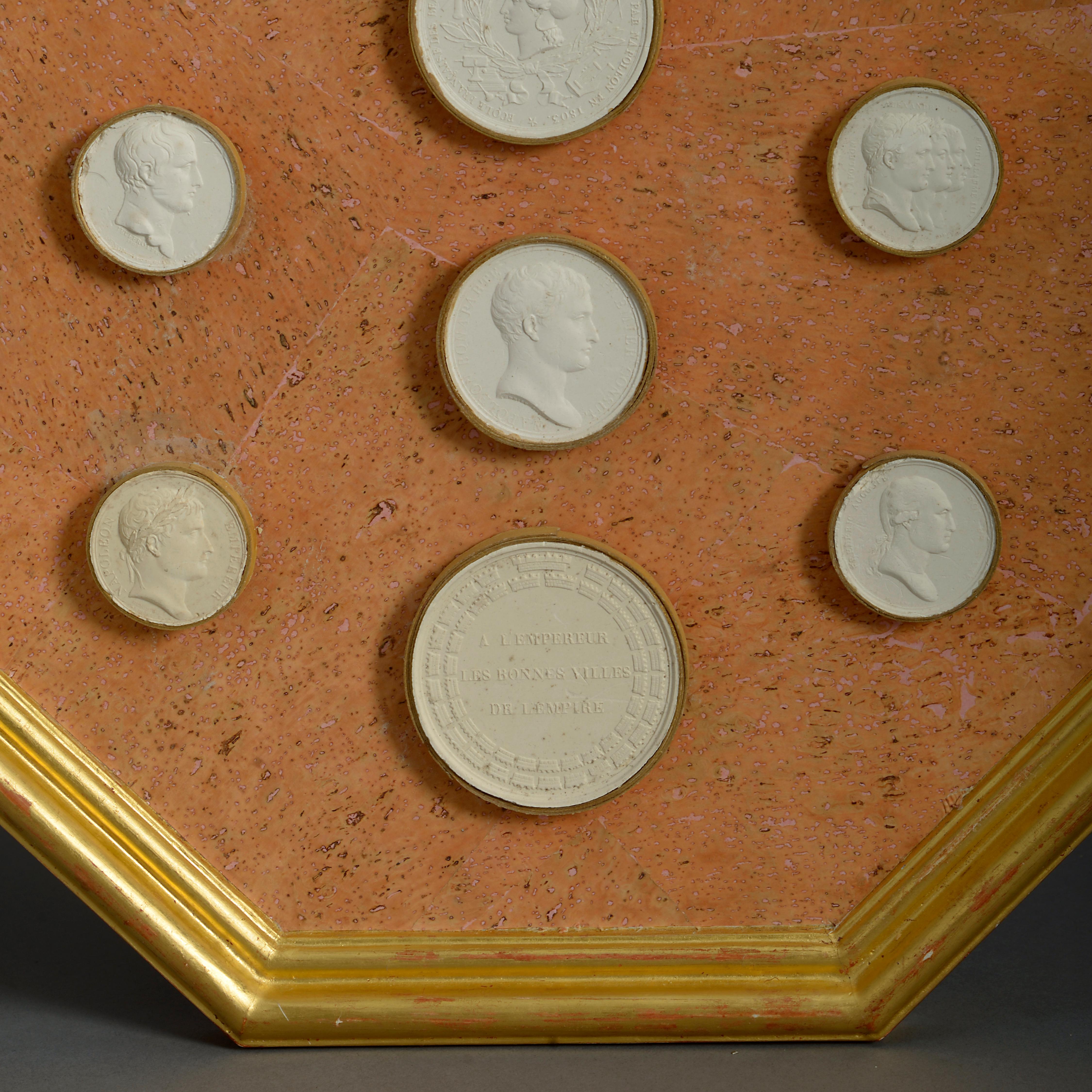 A pair of cork panels, mounted with Classical plaster intaglios. Set within octagonal giltwood frames.
