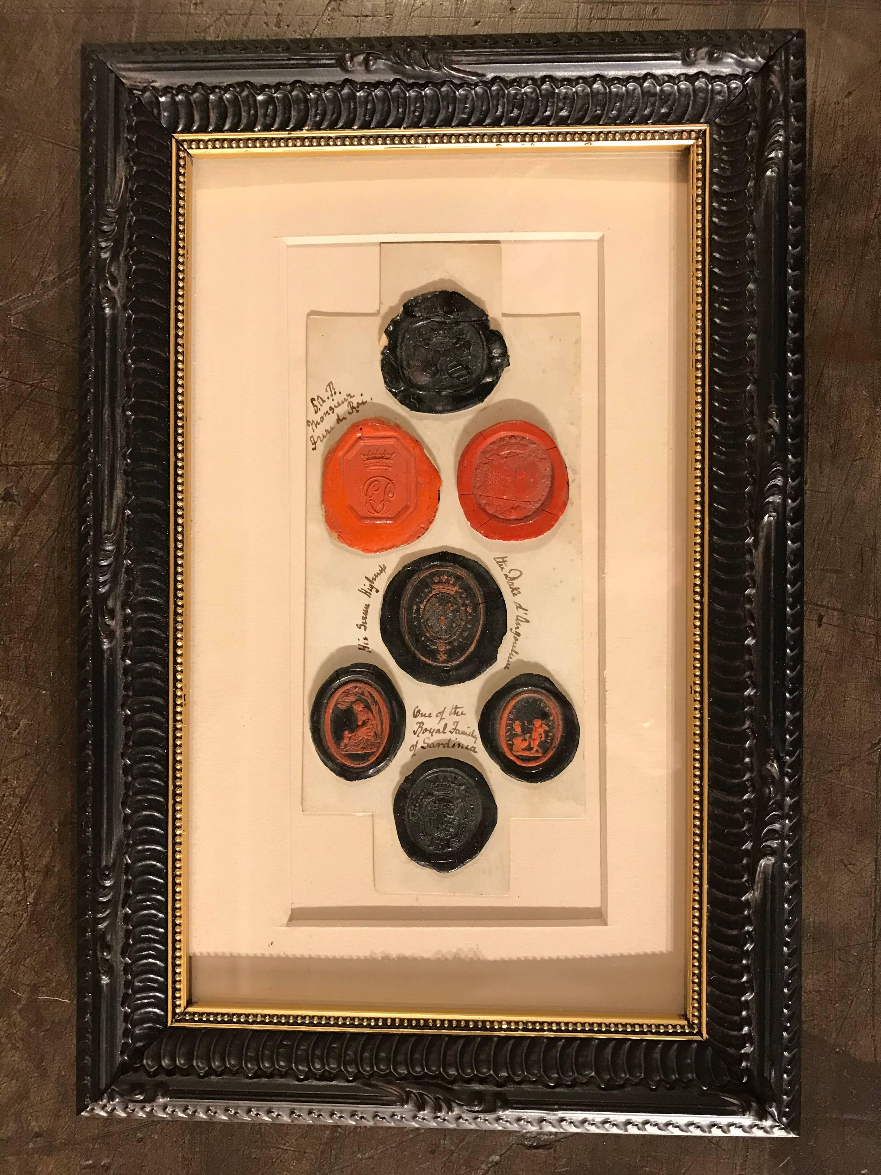 A framed pair of very interesting red and black wax intaglios seals with some inscriptions. Some are royal seals and all are beautiful impressions. The black seals with red highlights particularly unusual and intriguing. Mostly French and Italian.