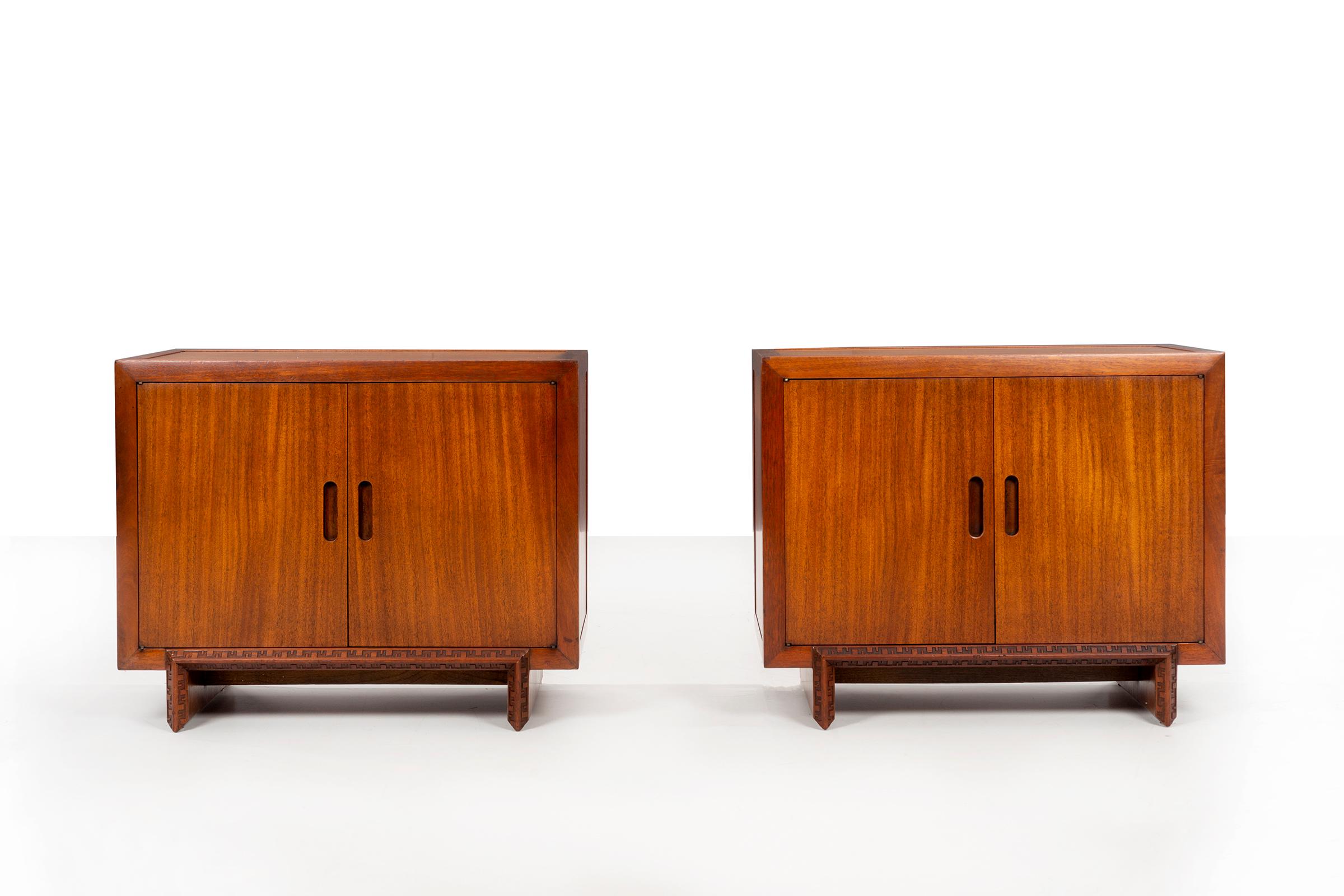 Frank Lloyd Wright pair of cabinets, mahogany veneer with solid mahogany carved design detailed edge, oil finish. (Stamped FLW).