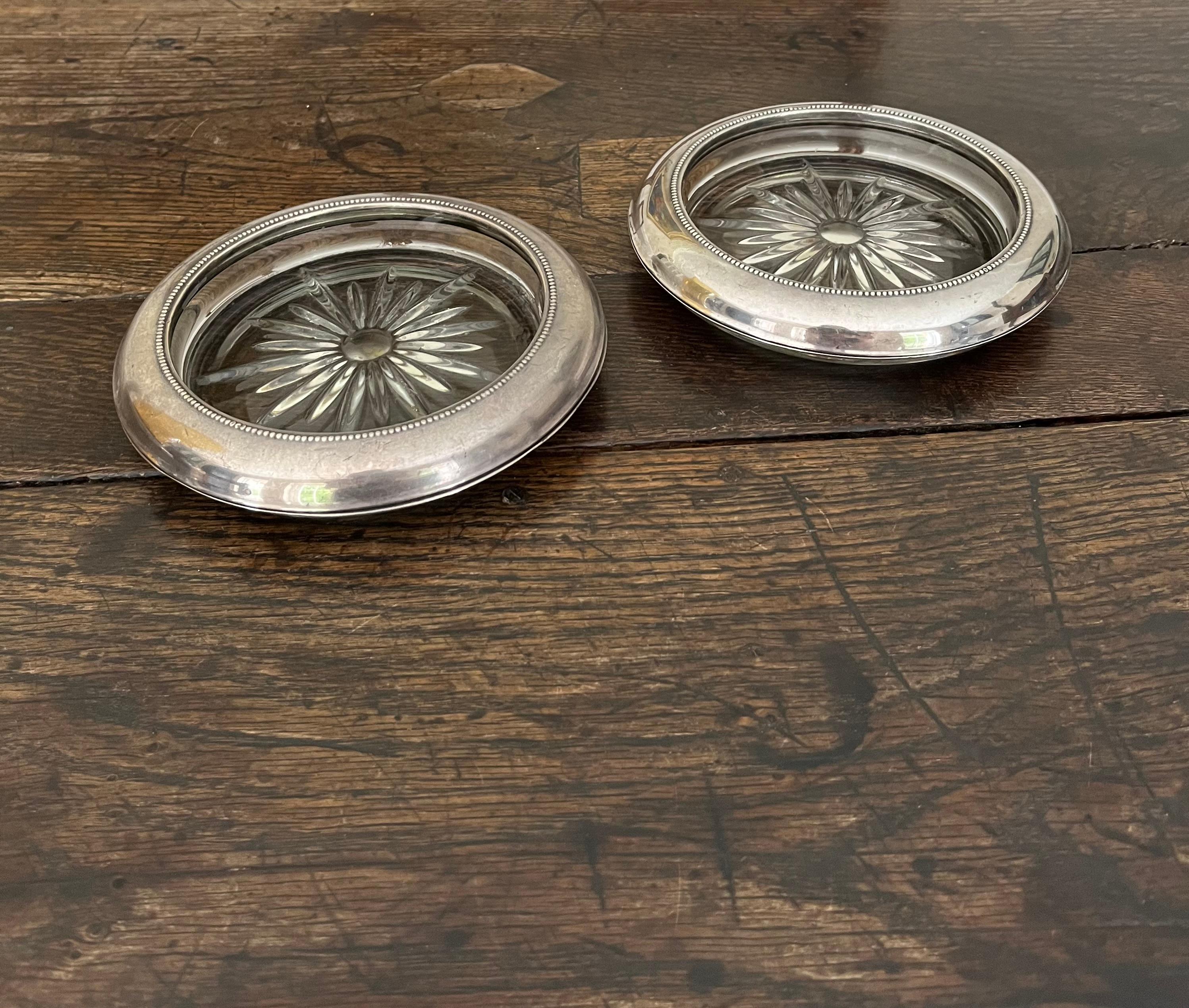 A pair of large glass and silver wine coasters by Frank M Whiting & co. Minor scratches and patination to the silver otherwise in good original condition. Great present idea. 