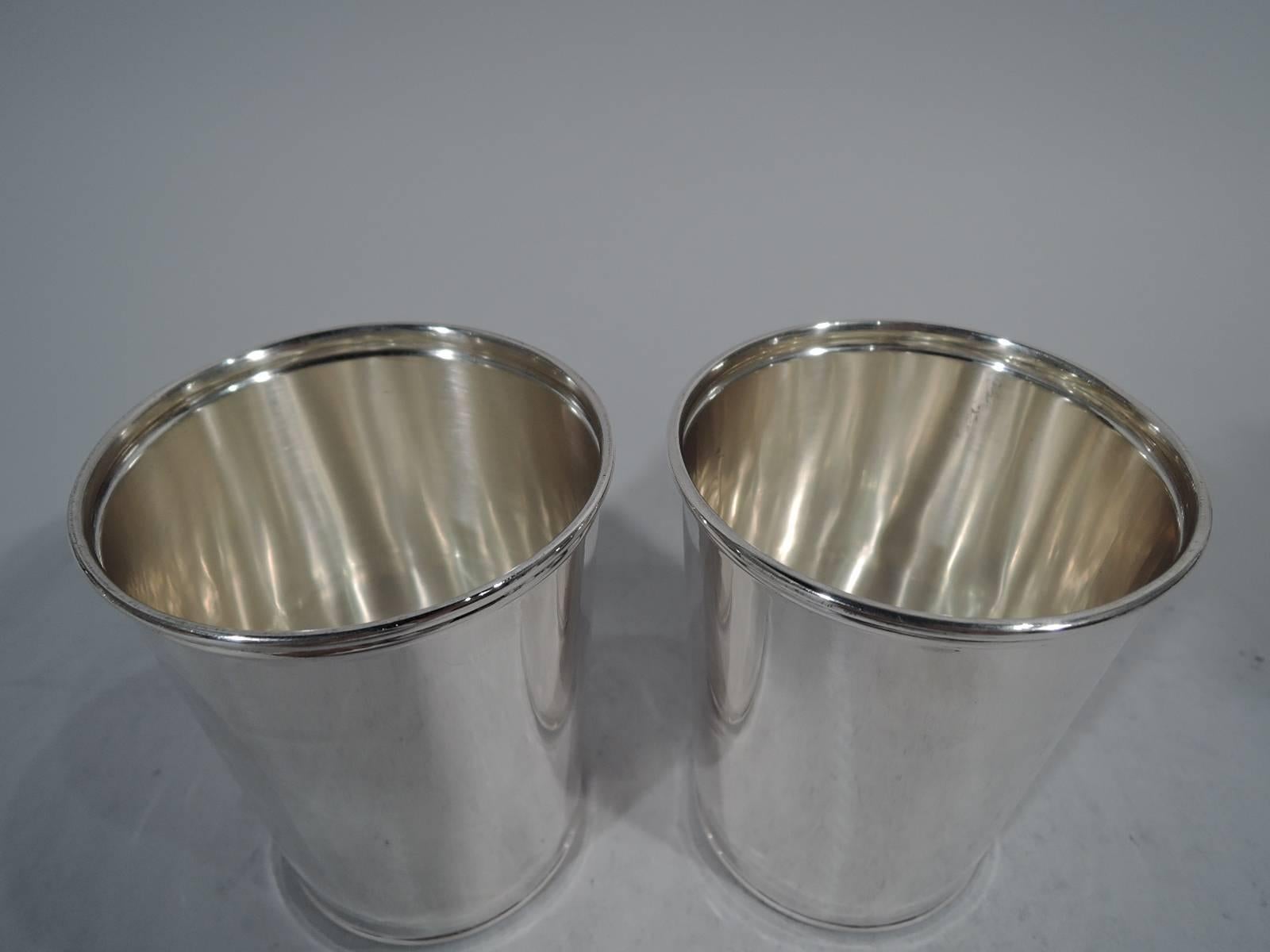 Pair of sterling silver mint julep cups. Made by Frank W. Smith in Gardner. Mass. Straight and tapering sides and molded rim. Nice barware by this maker, who was active until the late 1950s. Hallmark includes no. G106. Total weight: 5.4 troy ounces.