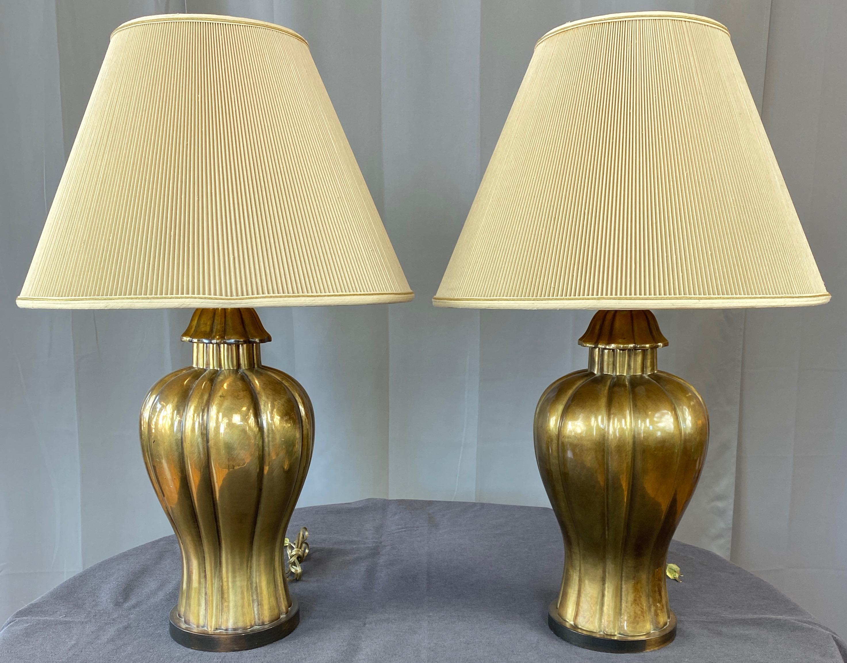 A very handsome pair of Hollywood Regency brass ginger jar table lamps with original shades by Frederick Cooper.

Curvaceous chinoiserie form with fluted body, neck, and cap. Elegant lines enhanced by a subtly antiqued brass finish with glossy