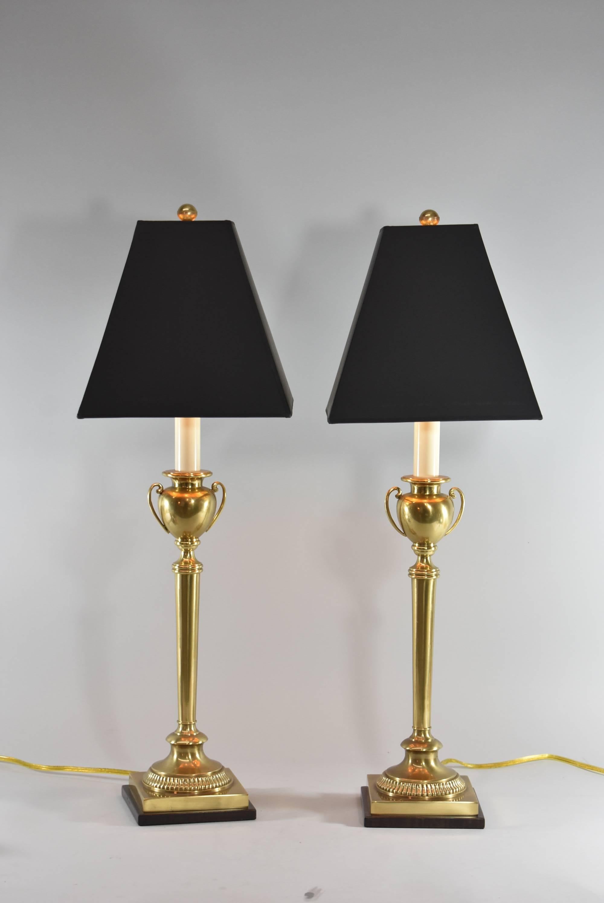 A very attractive pair of table lamps by Frederick Cooper. They feature a slender brass base with an urn form centre and a bronze colored metal base. The dimensions are 30