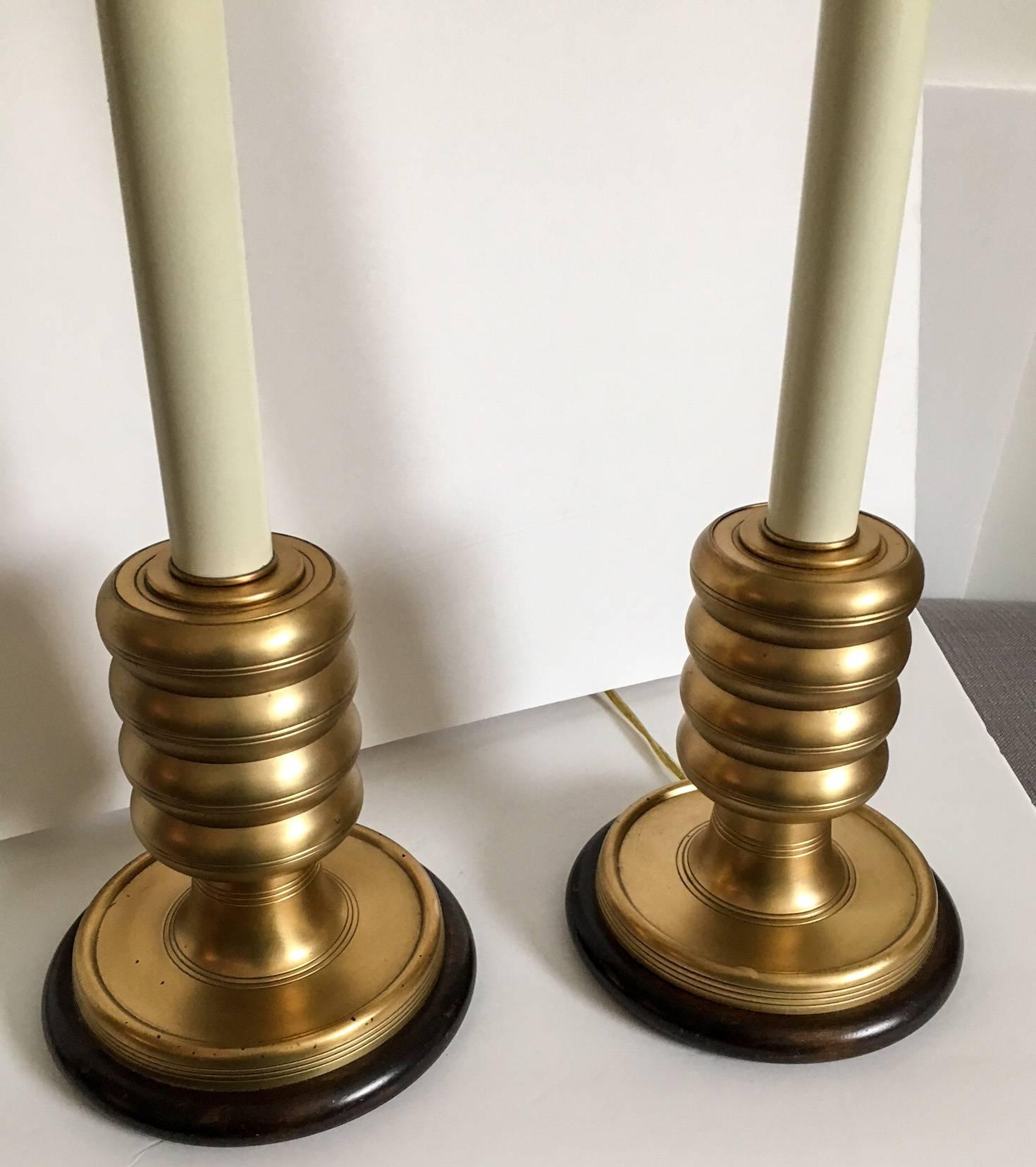 Offered is a pair of brass beehive style lamps on wooden round bases by Frederick Cooper. Body is cream plastic with a brass top sleeve. Original finials are included on the harps which were with the lamps when purchased. Marked with a Frederick