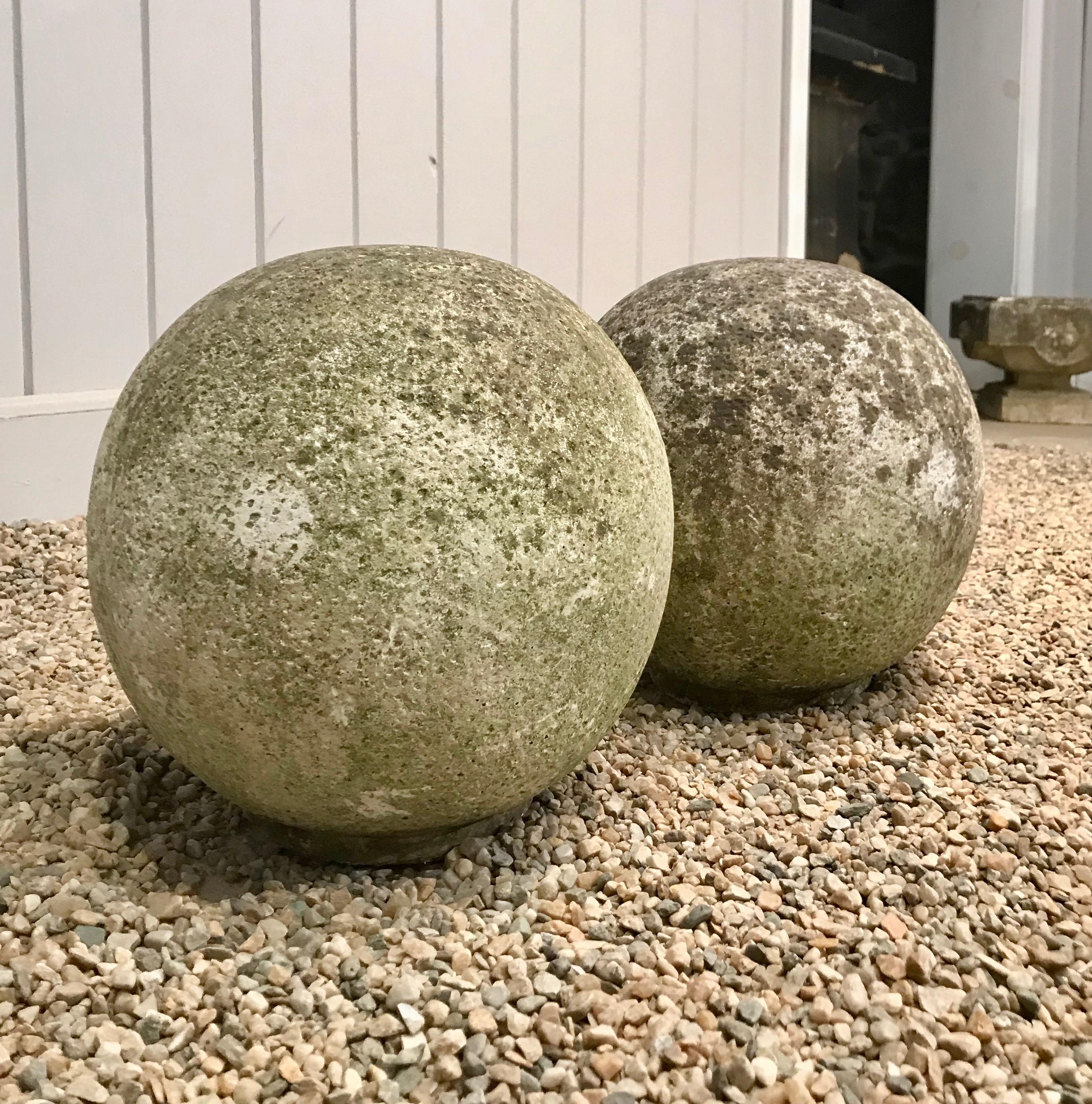 We love these cast stone balls for their stunning weathered surface with moss that will green up if placed in a damp and shady location. In very good vintage condition, with flat bottoms to prevent rolling, they would be wonderful flanking the
