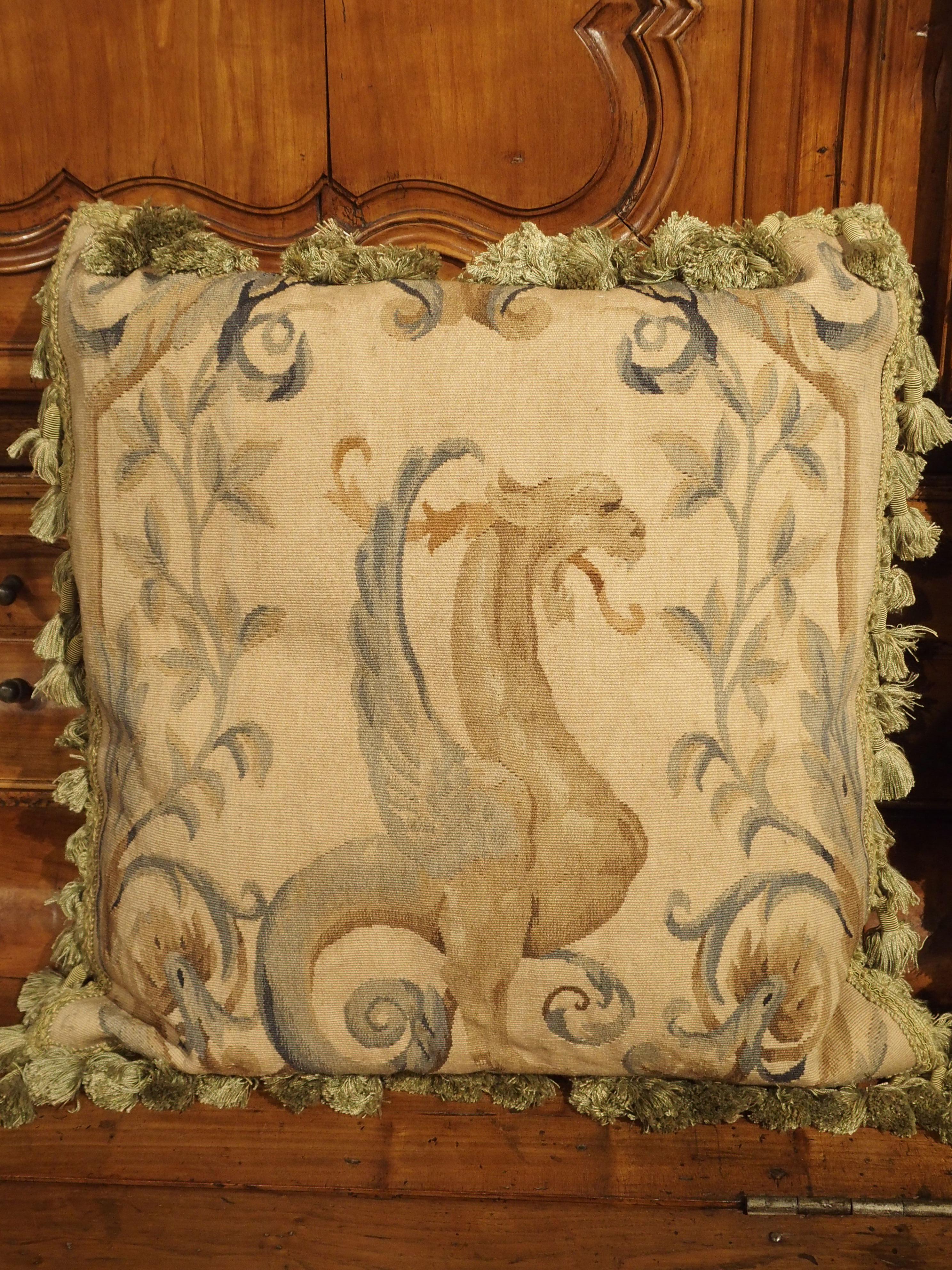These French pillows have Aubusson tapestry from the 1600s. Stunning half figures of winged griffins with the head and wings of an eagle and the body of a lion have been woven with meticulous skill. Each griffin rests upon a small platform. Varying