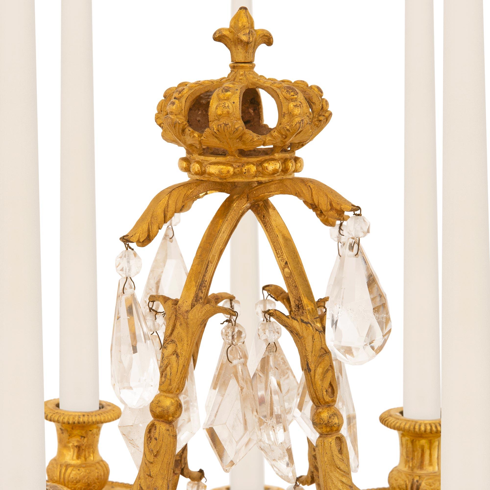A sensational and extremely high quality pair of French 17th century Louis XIV period ormolu and rock crystal candelabras, circa 1680. Each eight arm girandole is raised by a circular mottled base with fine seashell, floral patterns, and richly