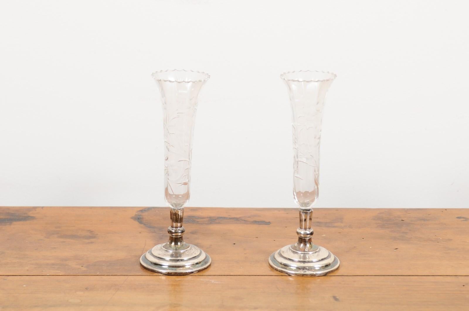 A pair of French Restauration period crystal bud vases from the early 19th century, with etched décor and silver bases. Created in France during the first quarter of the 19th century, each of this pair of bud vases charms us with its flaring lines