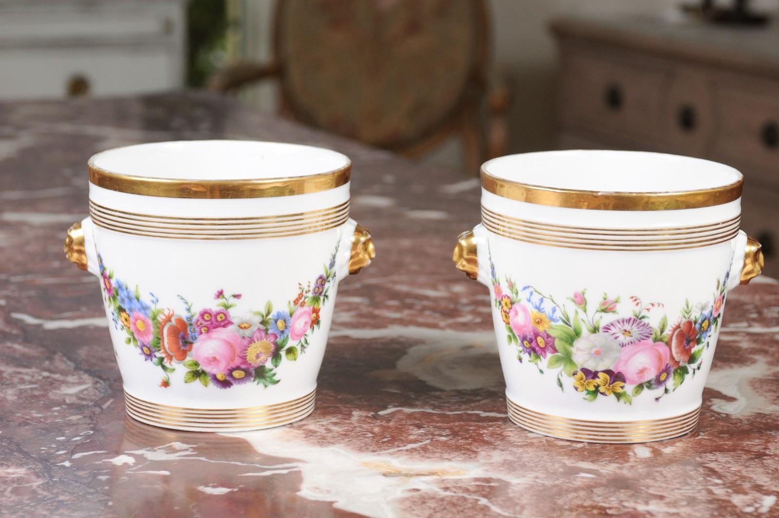 A pair of French Louis-Philippe period Paris porcelain cachepots from the mid-19th century, with hand-painted floral décor and gilt accents. Born in France at the end of the reign of King Louis-Philippe, each of this pair of cachepots features a