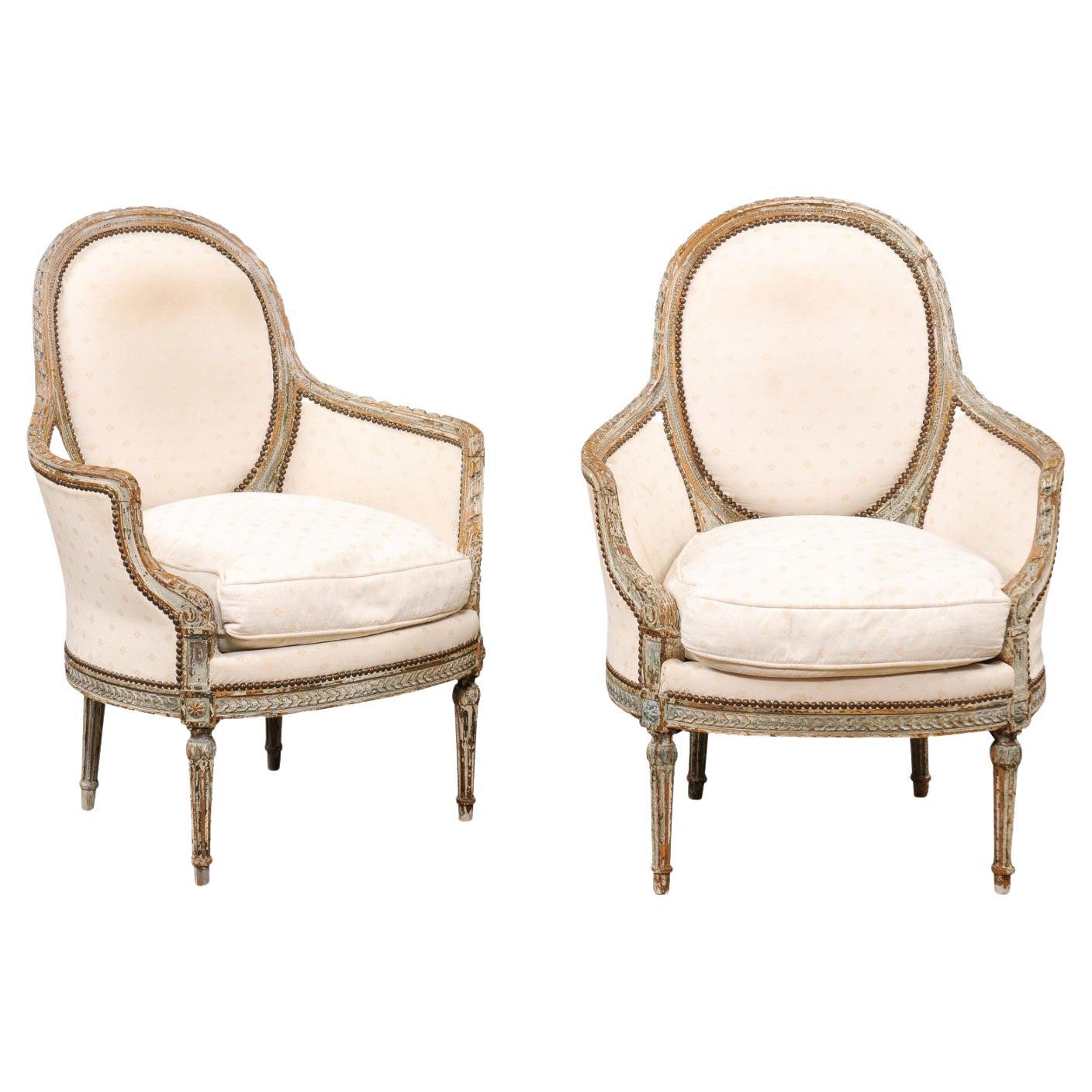 Pair of French 1850s Louis XVI Style Painted Bergère Chairs with Carved Décor