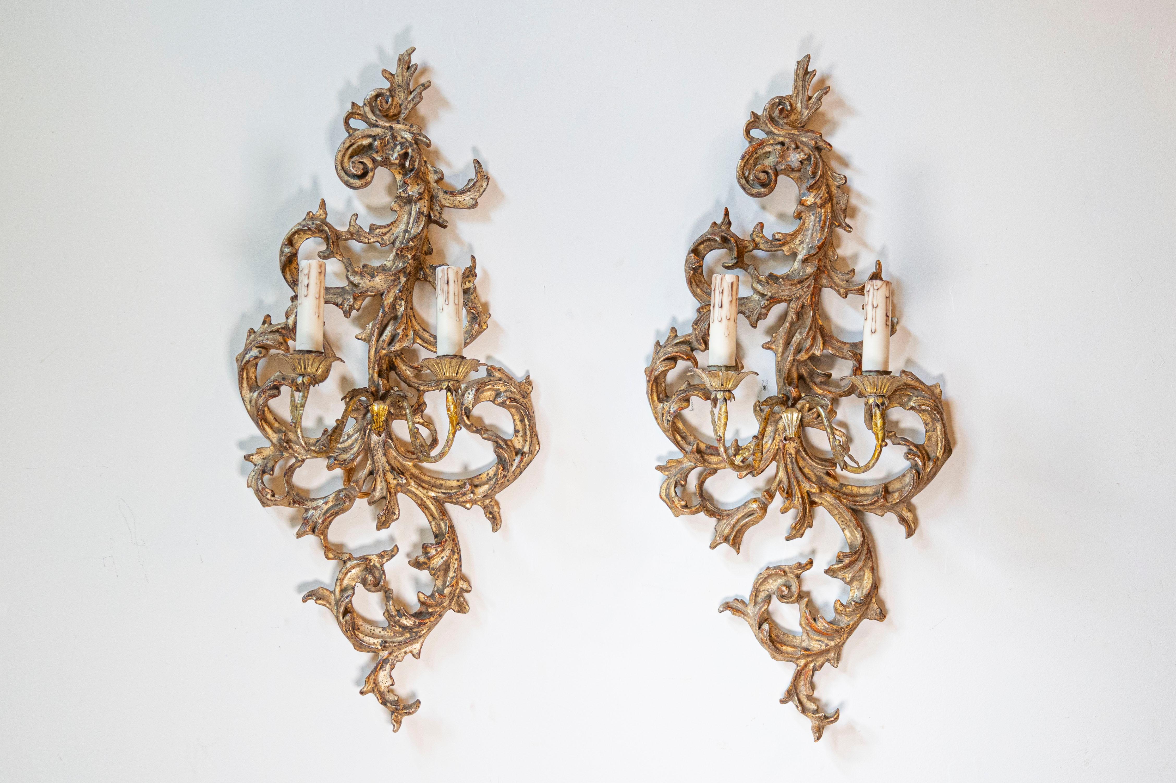 Paire d'appliques à deux lumières en bois doré de style néo-rococo français, datant du milieu du XIXe siècle. Cette paire d'appliques françaises en bois doré est née dans les années qui ont suivi l'arrivée du Second Empire avec Napoléon III comme