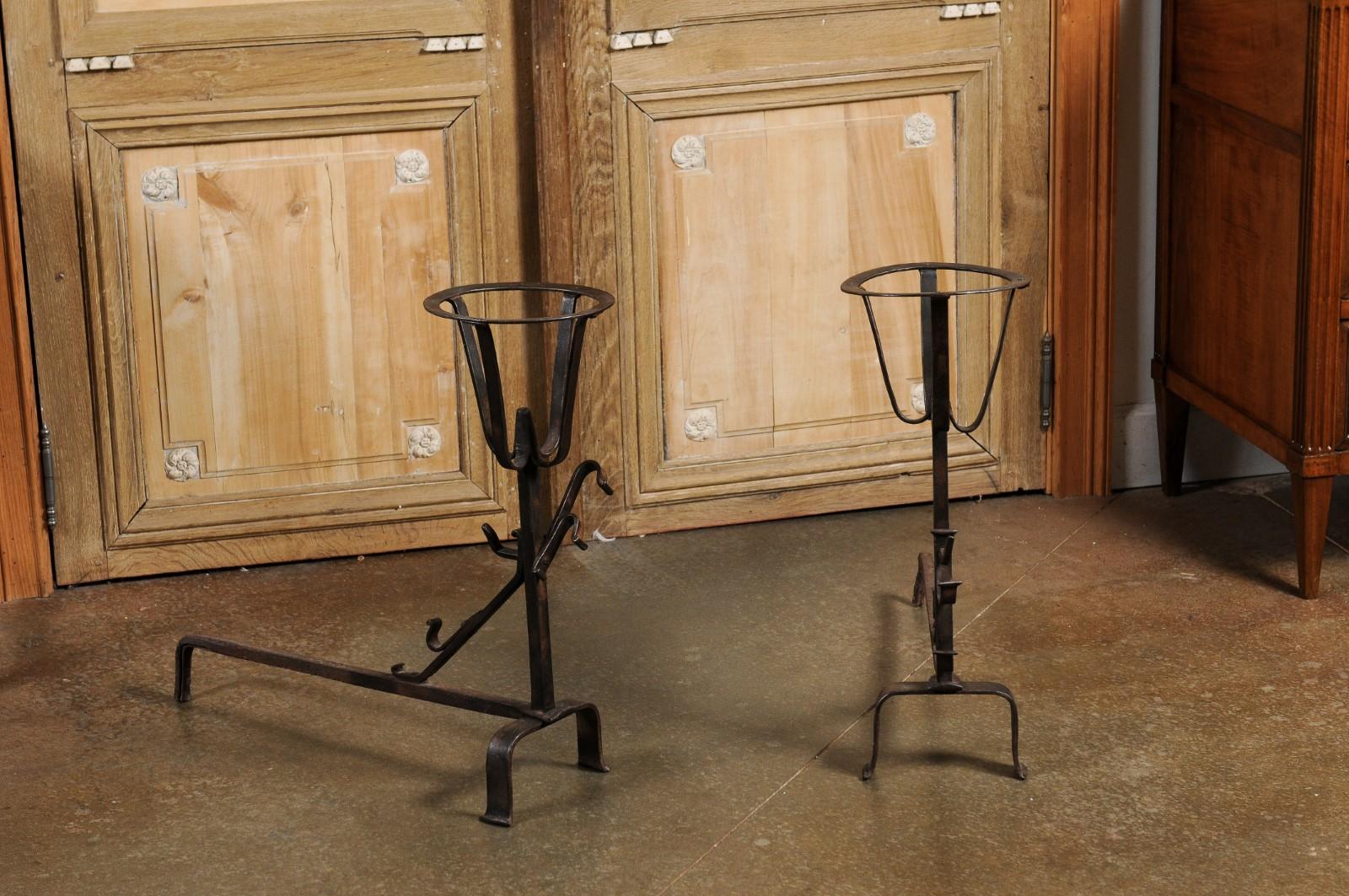 A pair of French Napoléon III period andirons from the late 19th century. Created in France at the end of Emperor Napoléon III's reign to hold flaming firewood slightly above the firebox floor, each of this pair of andirons features a circular