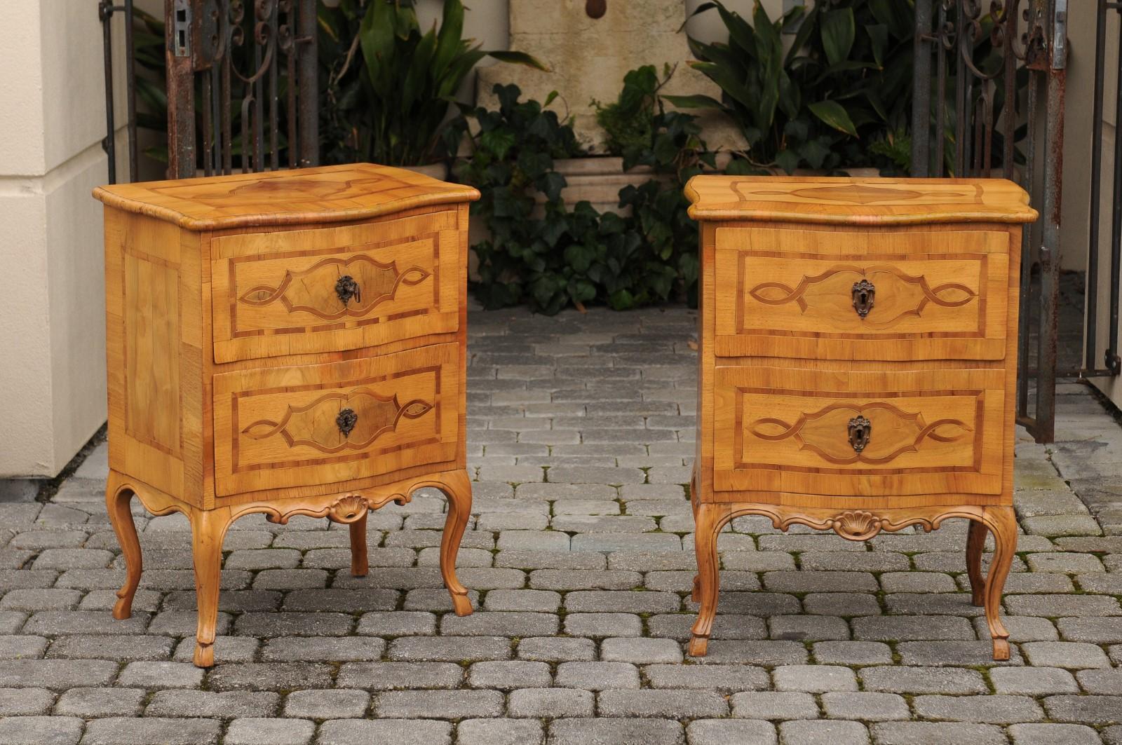 A pair of French Louis XV style walnut veneered petite commodes from the third quarter of the 19th century, with inlaid cartouches and cabriole legs. Born in France at the end of Napoleon III's reign, each of this pair of exquisite commodes features
