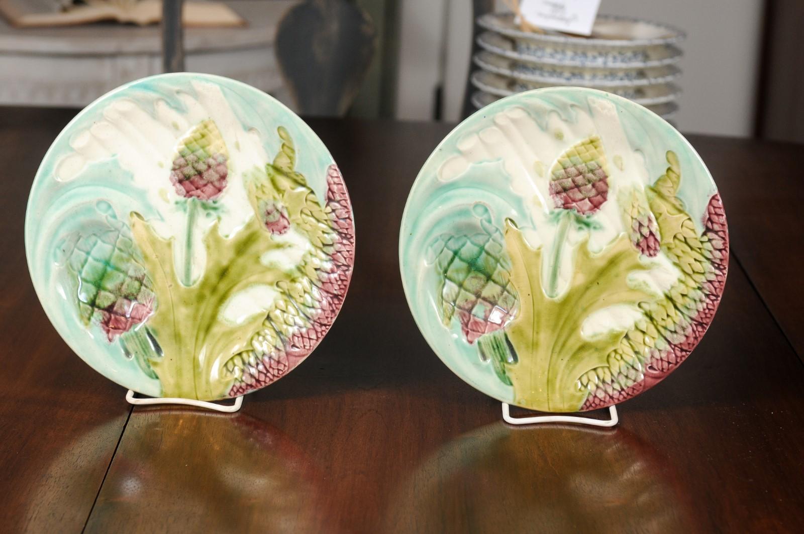 A pair of French late 19th century majolica asparagus and artichoke plates from Lunéville. Born in the Lorraine area of France during the last quarter of the 19th century, this pair of asparagus and artichoke plates features a turquoise ground