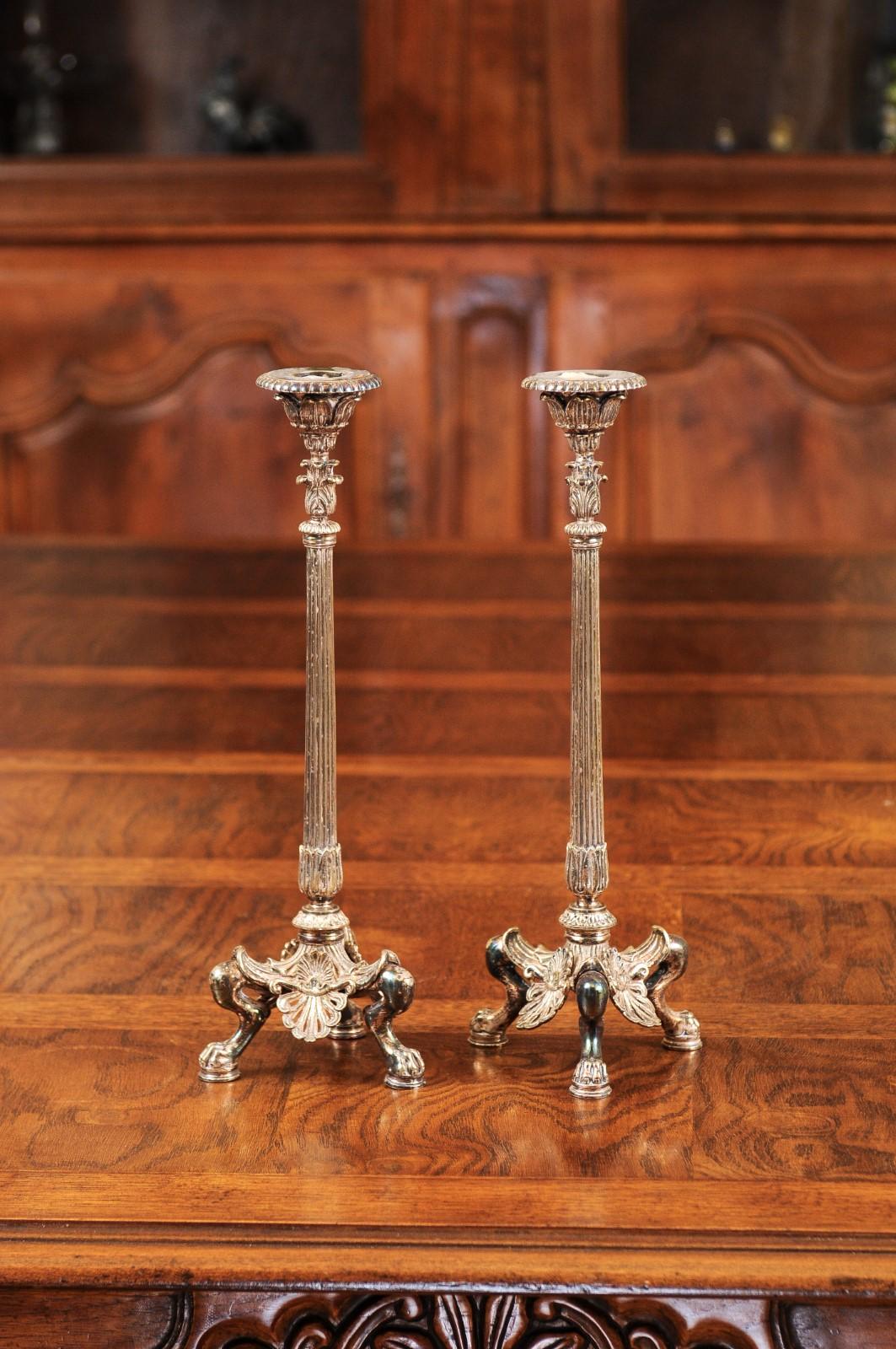 A pair of French silver candlesticks from the late 19th century, with foliage, palmettes and lion paw feet. Created in France during the last quarter of the 19th century, each of this pair of silver candlesticks features a fluted shaft topped with