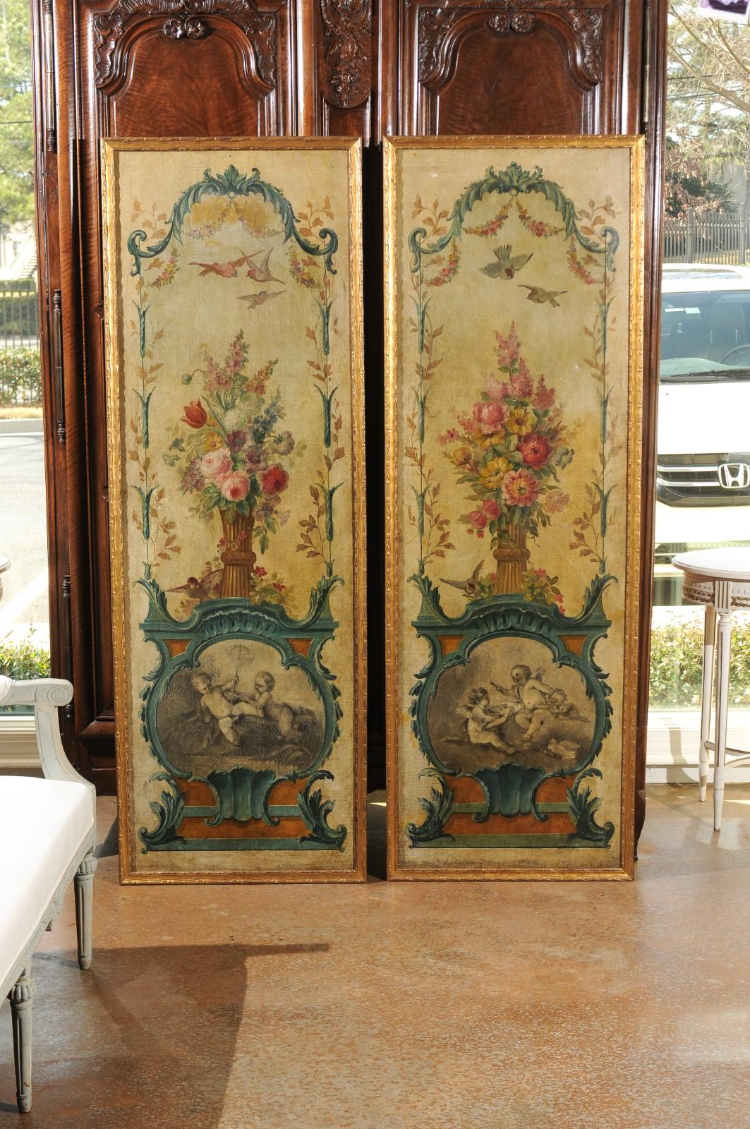 A pair of French Louis XV period framed painted panels from the 18th century, with floral, bird and angel motifs. Born in France during the reign of king Louis XV, each of this exquisite pair of panels features a lovely painted décor depicting a