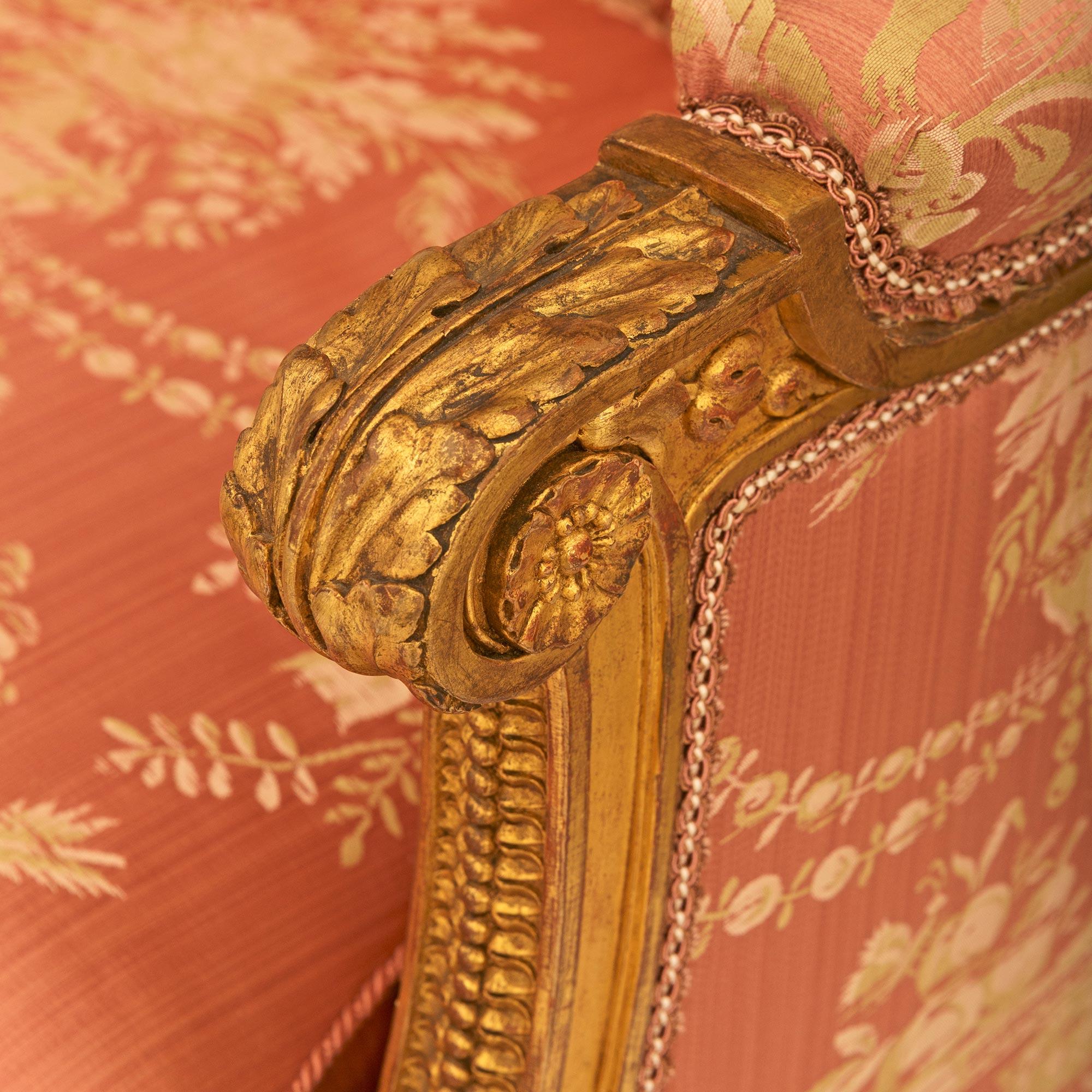 Pareja de sillones Bergère franceses de madera dorada de la época Luis XVI Tapicería en venta