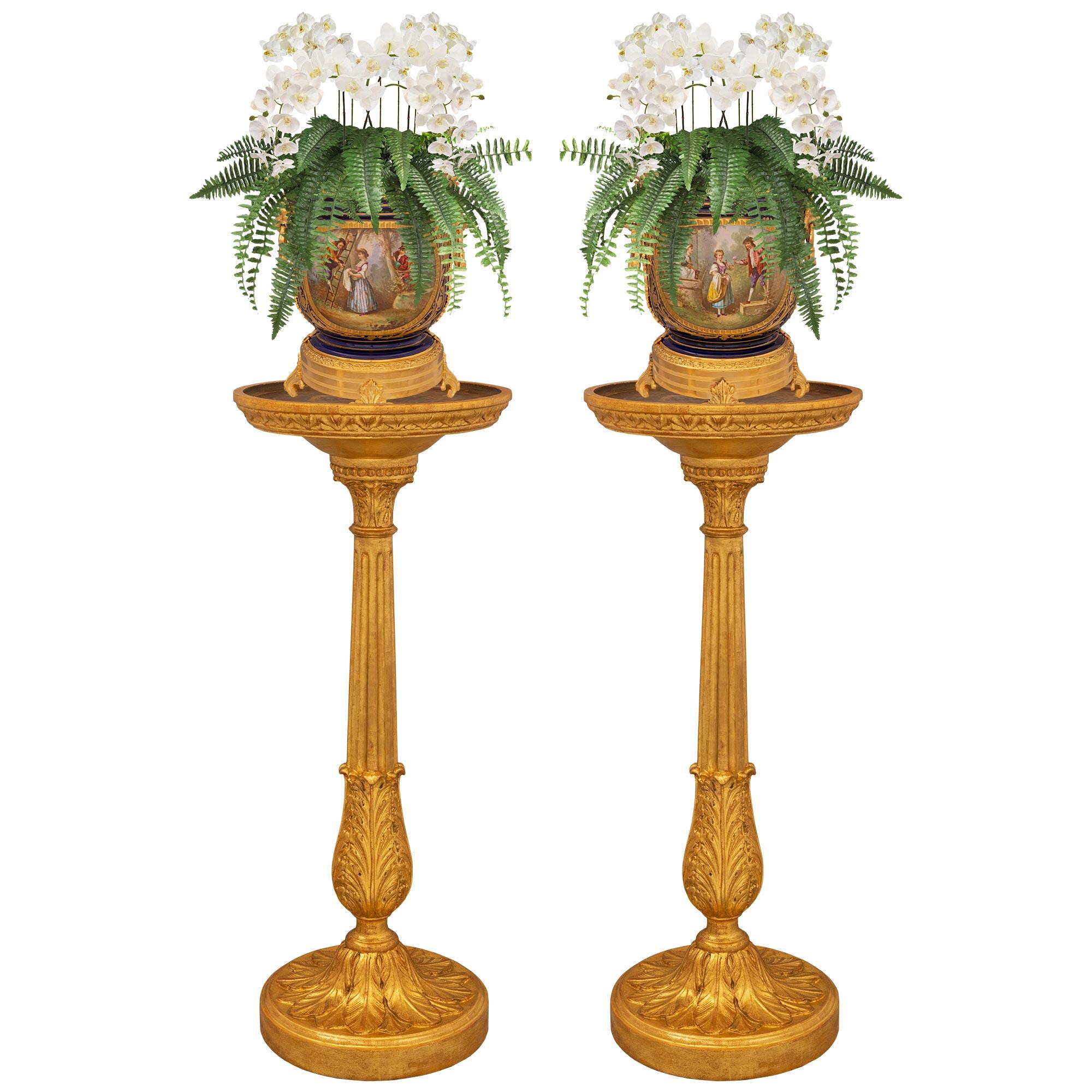 A beautiful and most elegant pair of French 18th century Louis XVI period giltwood and patinated wood pedestals/plant stands. Each pedestal is raised by a circular giltwood base with a fine mottled border and richly carved palmettes. The baluster