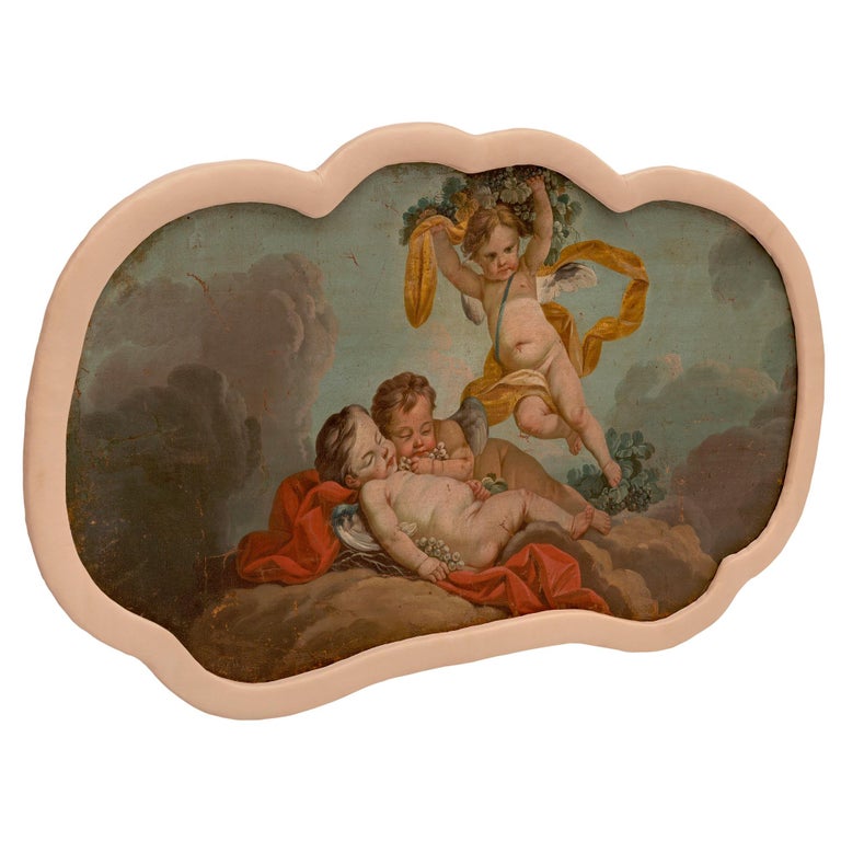 A beautiful and most charming pair of French 18th century oil on canvas paintings. Each most decorative and colorful cloud shaped painting displays a lovely scalloped shaped design with a fine fabric border. The two wonderfully executed scenes