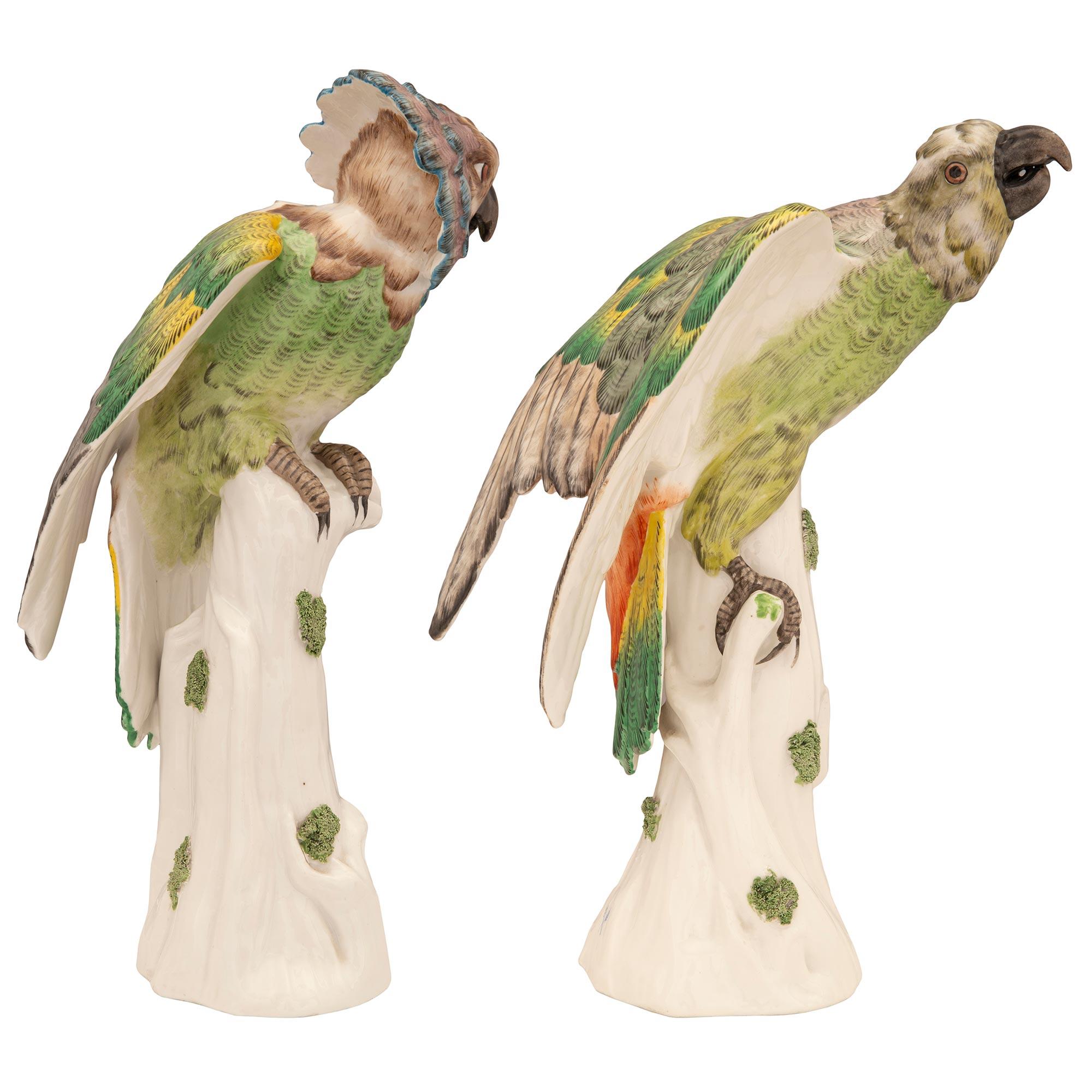 A striking and most charming true pair of French 18th century De La Courtille porcelain signed statues of hawk-headed parrots. Each wonderfully executed parrot is raised by a lovely trunk and branch designed base with charming moss growing on it.