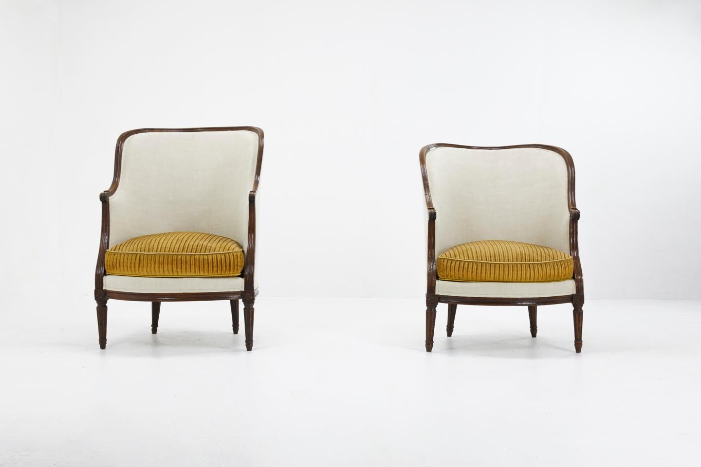 Pair of French 18th century walnut armchairs of nice simple style, upholstered in vintage linen and cushions covered in a vintage cotton corduroy. 

Made as ladies' and gentleman's so slightly different in size.

Measures: Seat height 48
