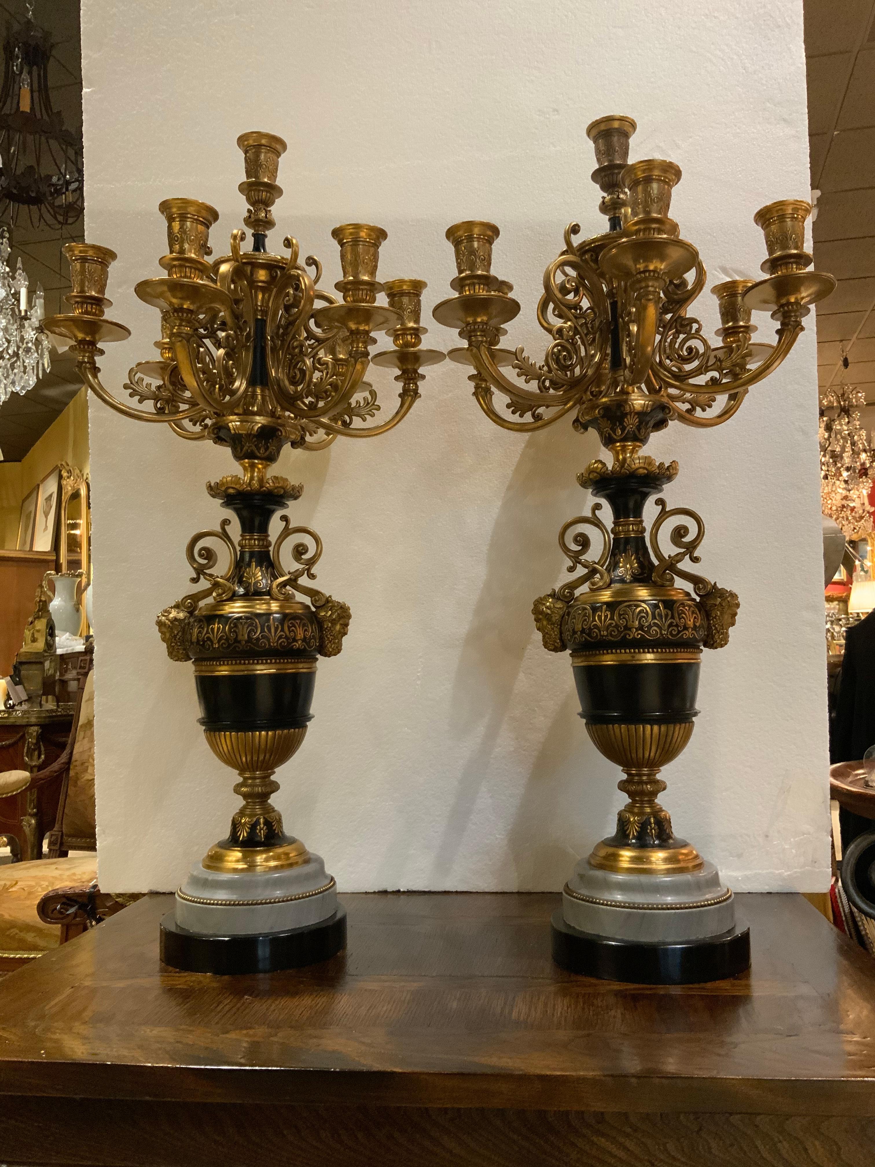 Pair of French candleabrum with marble and black stone base, having scrolled handles
With Bacchus mask joins. Each with seven candle nozzles, the standard with anthemion
Design in relief.