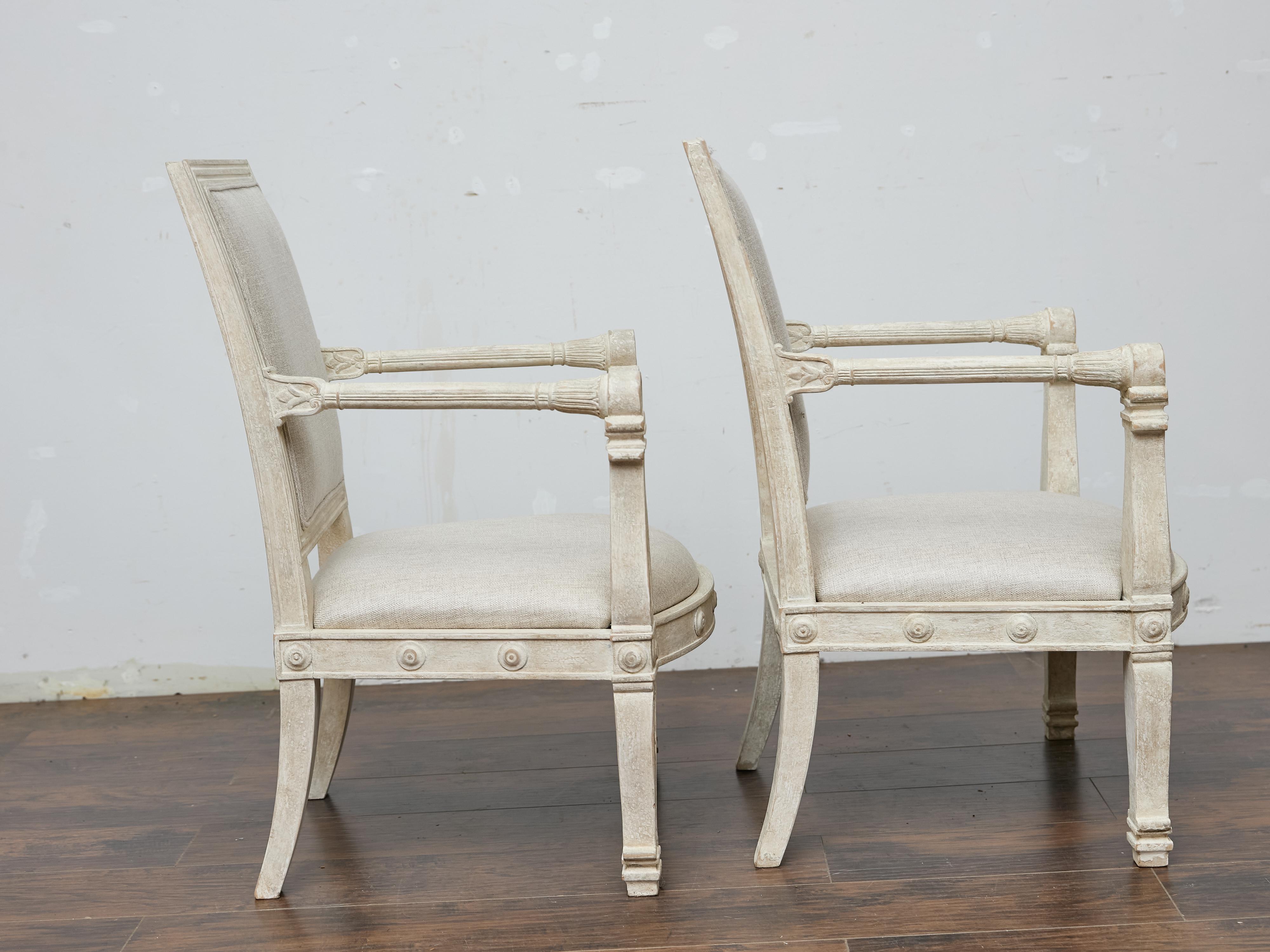 20th Century Pair of French 1920s Painted Armchairs with Carved Details and Linen Upholstery For Sale