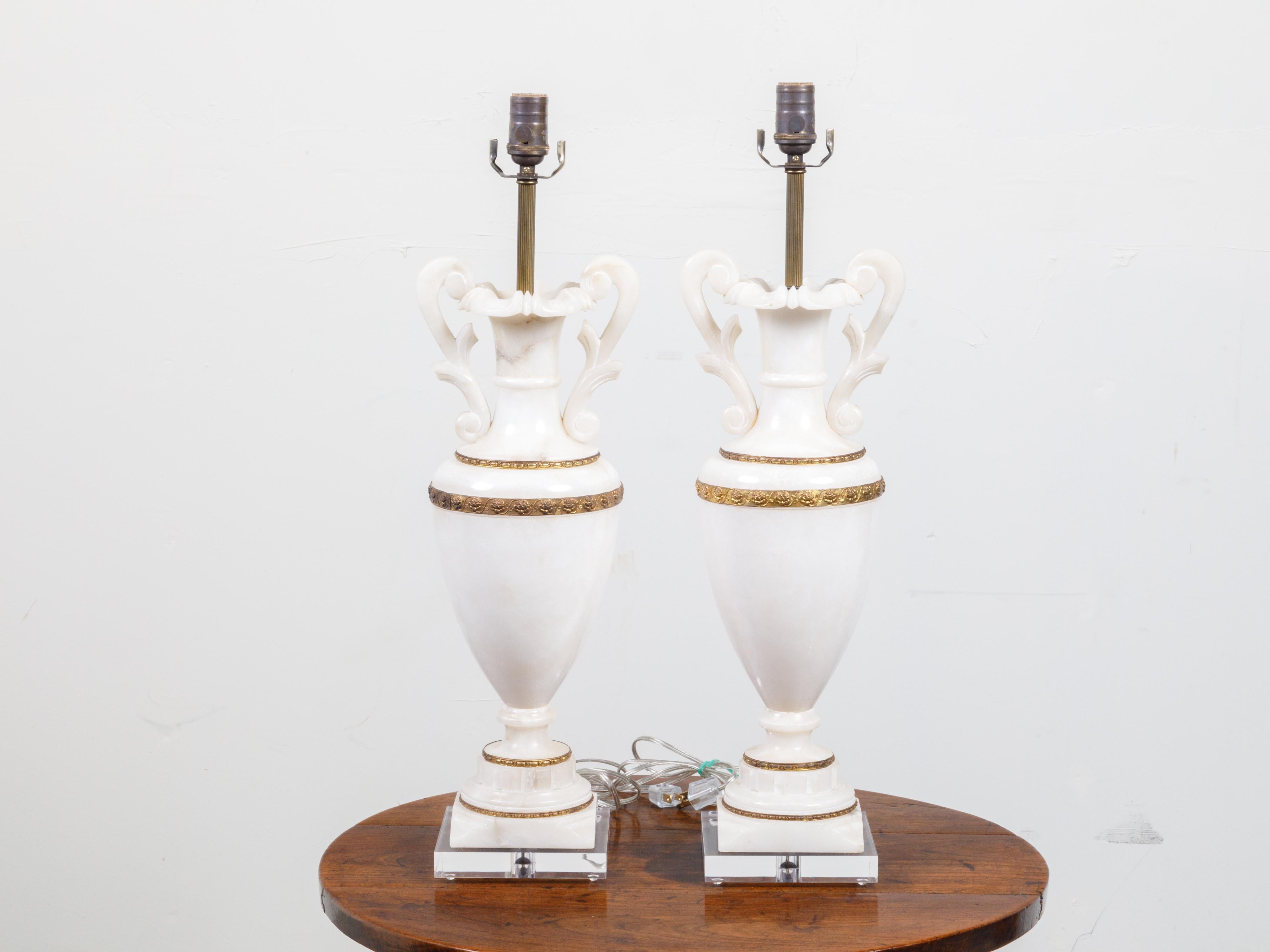 Paire de lampes de table en forme de vase en marbre et bronze du début du 20e siècle, avec volutes et bases en lucite. Créée en France durant le premier quart du 20e siècle, cette paire de lampes de table, câblée pour les États-Unis, présente un