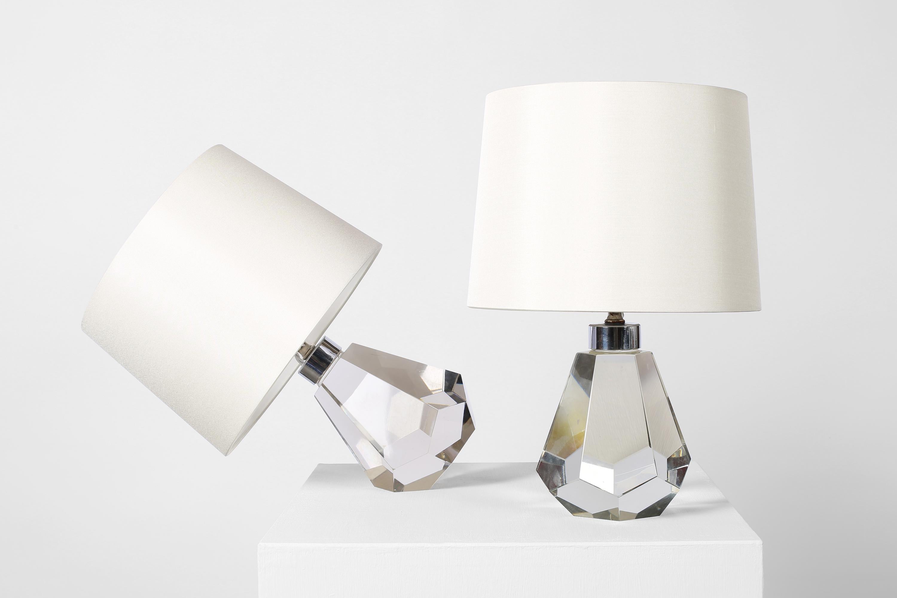A rare pair of Art Deco faceted crystal glass table lamps of jewel-like form. The angular base allowing the lamps to sit vertically, or at an angle, much like Jacques Adnet’s Baccarat crystal ball lamp. French, c. 1930s. Supplied with off white