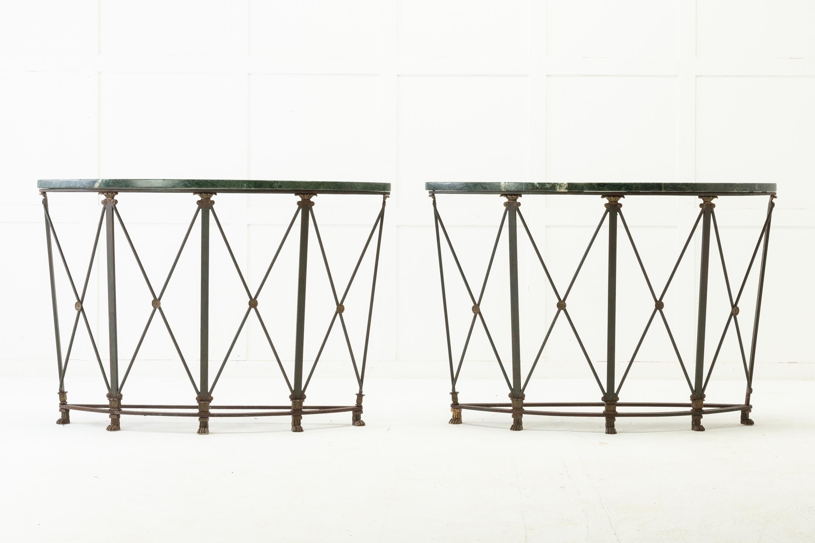 Good quality pair of 1940s French iron, half moon console tables with their original green marble tops.

Having iron legs with brass decorations at the top and bottom with their original green paint and standing on tiny sets of five lion's paw