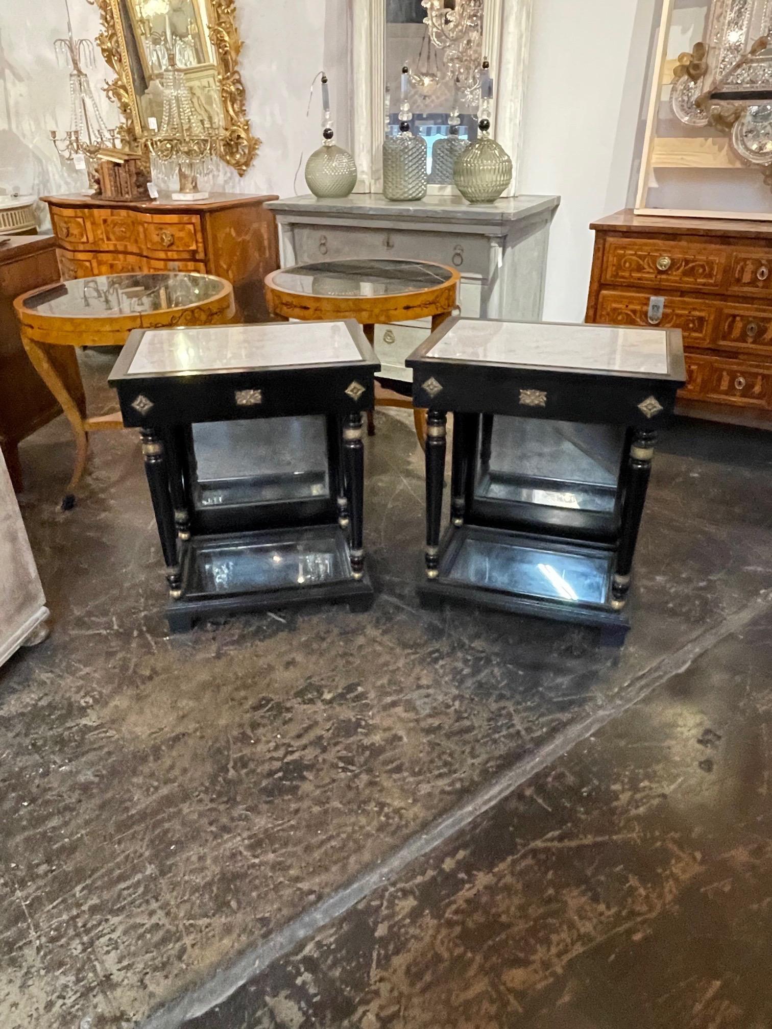 Lovely pair of French 1940s Jansen style black lacquered side tables. Very nice inlaid white marble tops and mirrored bases. Great for a variety of decors. So pretty!!