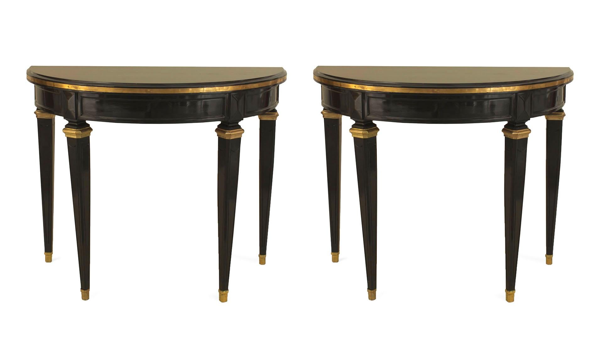 Pair of French Louis XVI-style (1940s) ebonized demilune shaped console tables with bronze trim and resting on 4 square tapered legs. (Attributed to JANSEN) (PRICED AS Pair)
