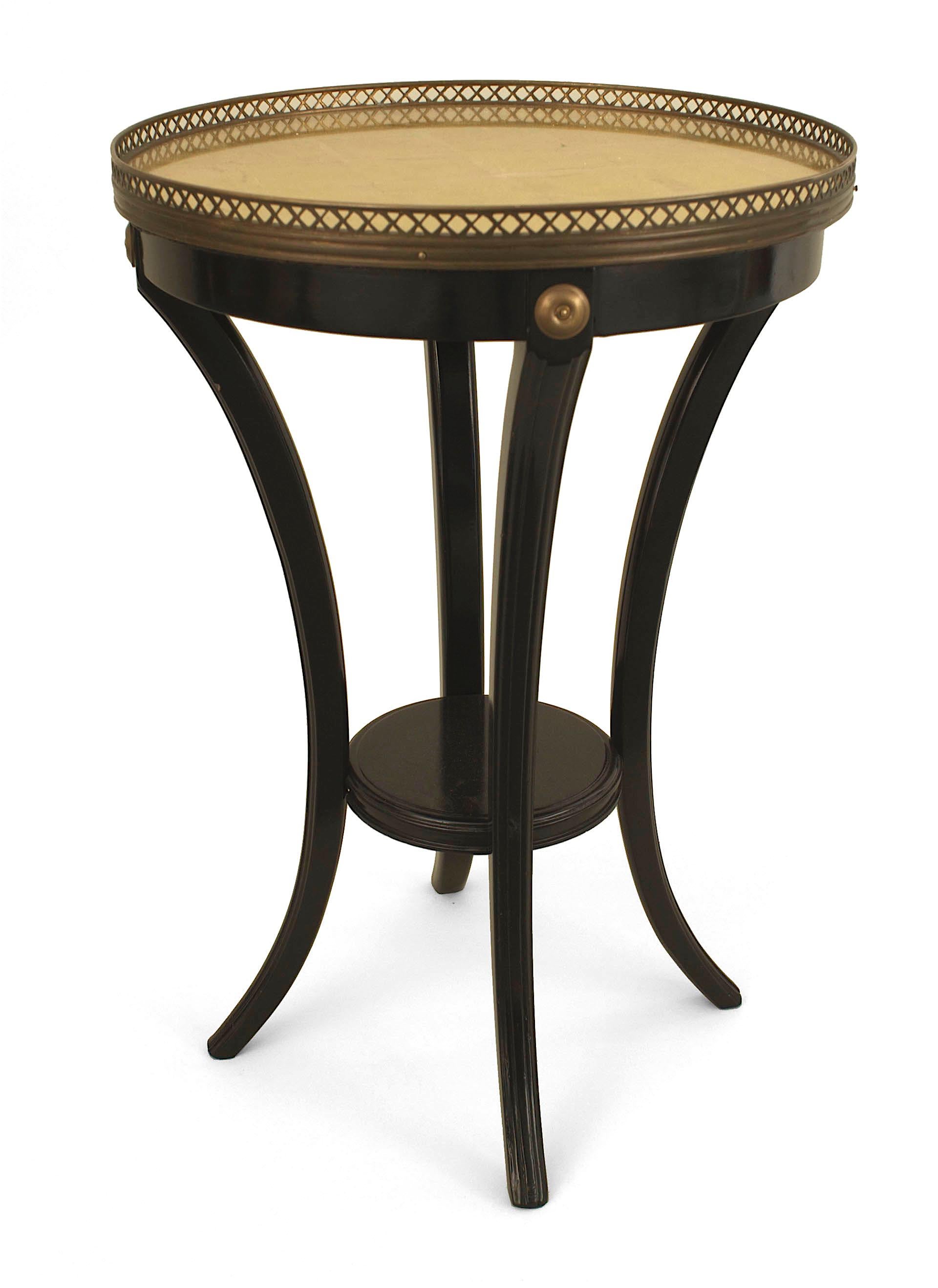 Pair of French Louis XVI-style (1940s) ebonized end tables with a round small shelf stretcher and a gilt glass round top having a filigree brass gallery. (stamped: JANSEN) (PRICED AS Pair)
