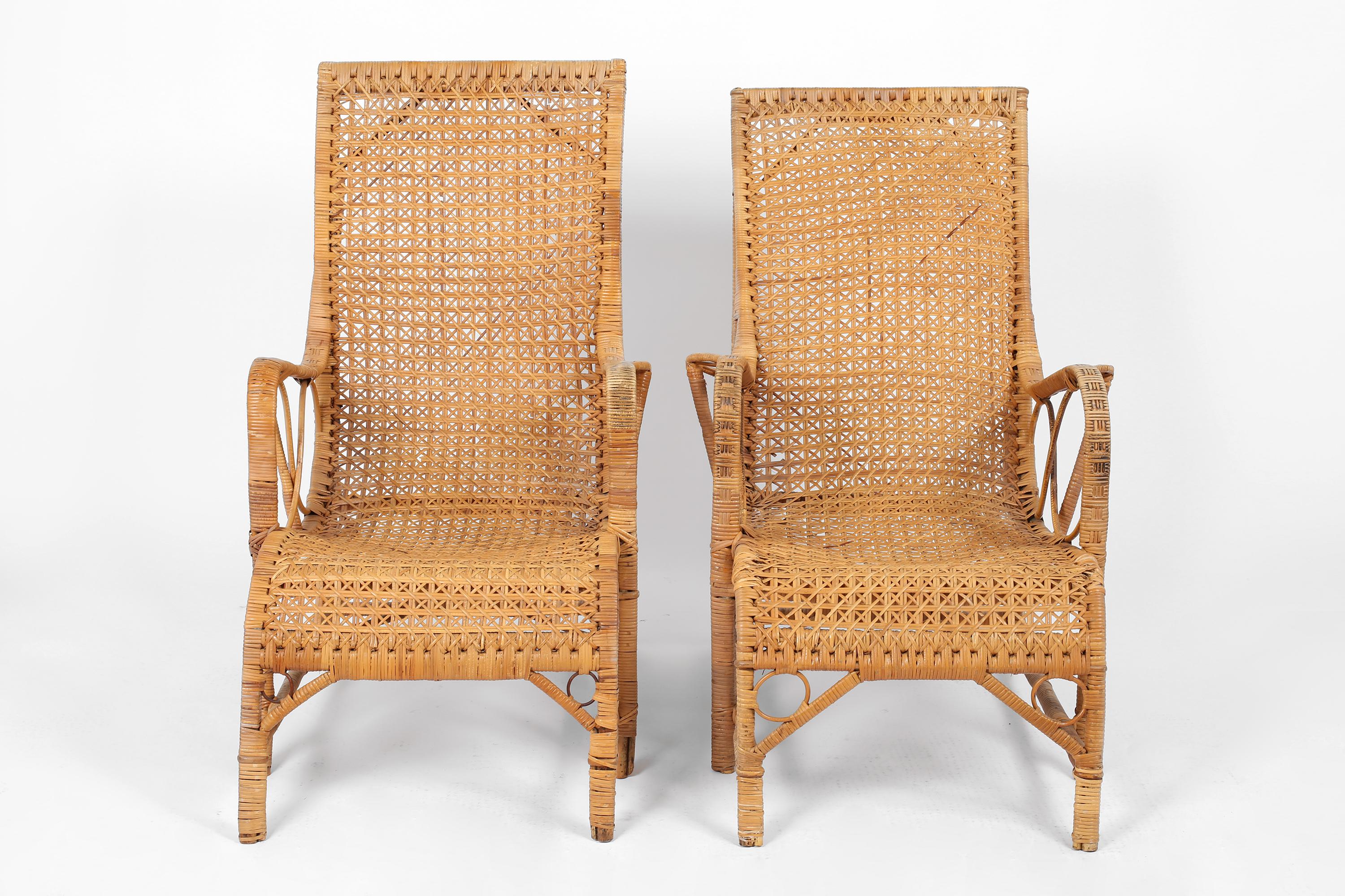 A near pair of large, elegant rattan loungers with cane binding and scrolling, intricately woven seats. French, c. 1940.