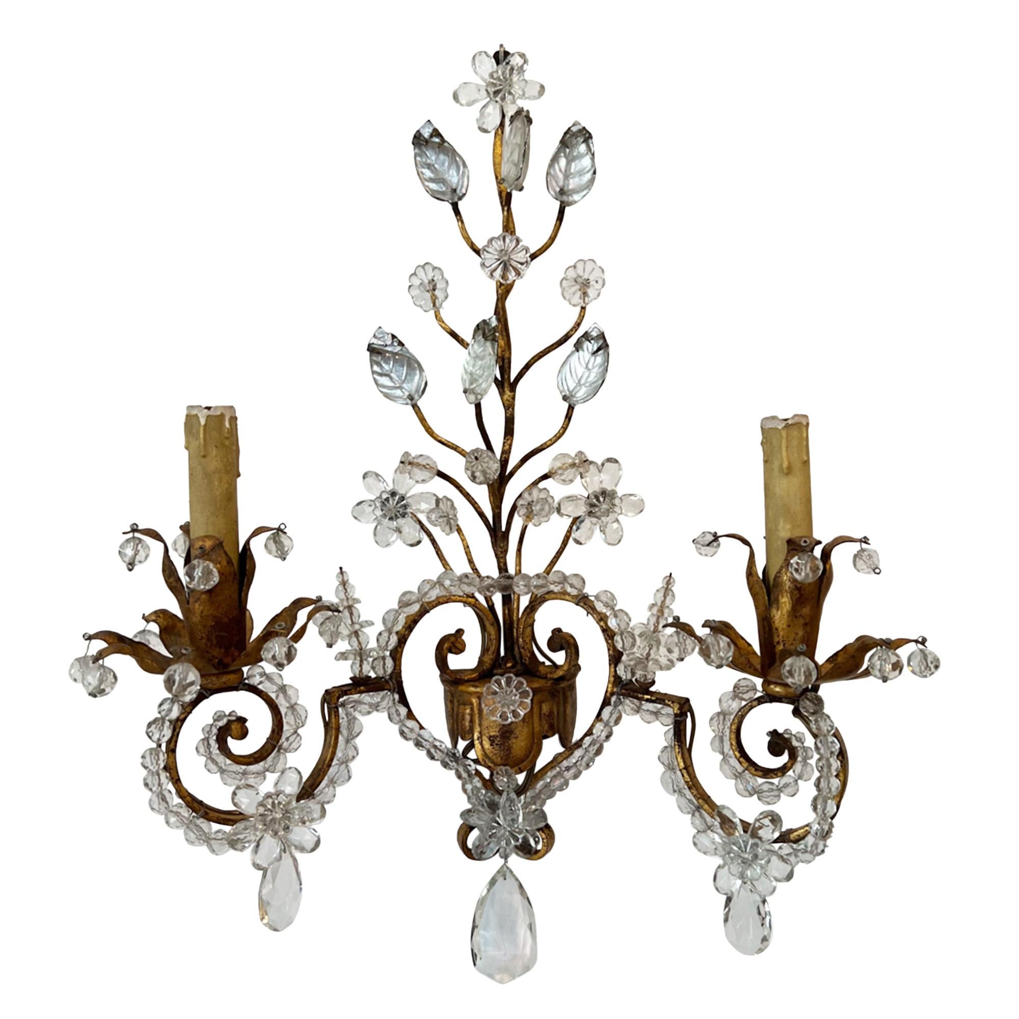 A highly decorative pair of antique wall lights, made in France in the 1950s.

Made in the manner of the lighting designer and maker Maison Baguès, these sconces are crafted from gilt metal and crystal. Lovely detail, including the heart shaped