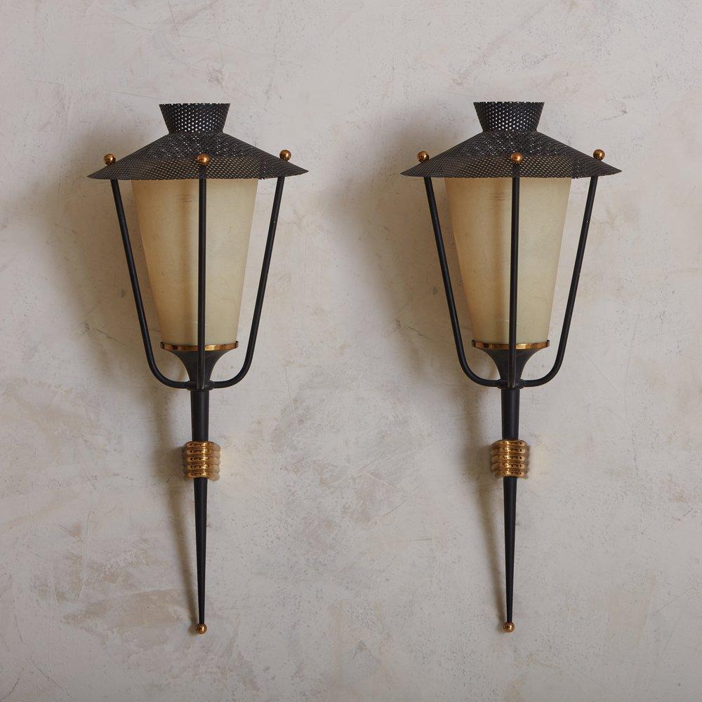 A pair of 1950s sconces by Parisian firm, Maison Arlus. This pair features black perforated metal, a black metal enamel arm and lacquered brass detailing. The interior shade is paper and is original. These have been fully rewired for US use.


