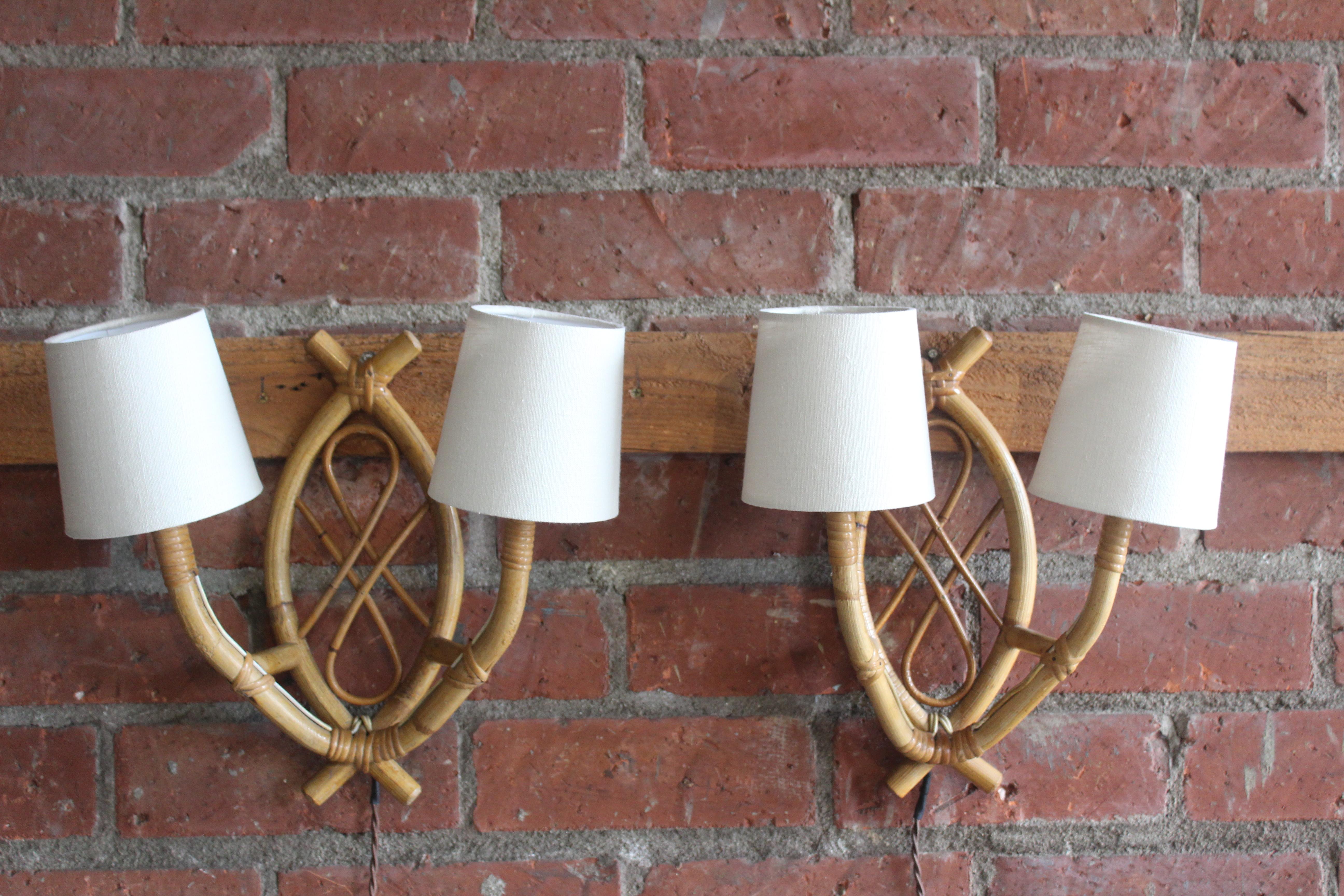 Pair of vintage 1960s French bamboo sconces attributed to Louis Sognot. The pair are in wonderful condition and have been rewired for U.S standards. They include custom made shades in Belgian linen. Price is for the pair.