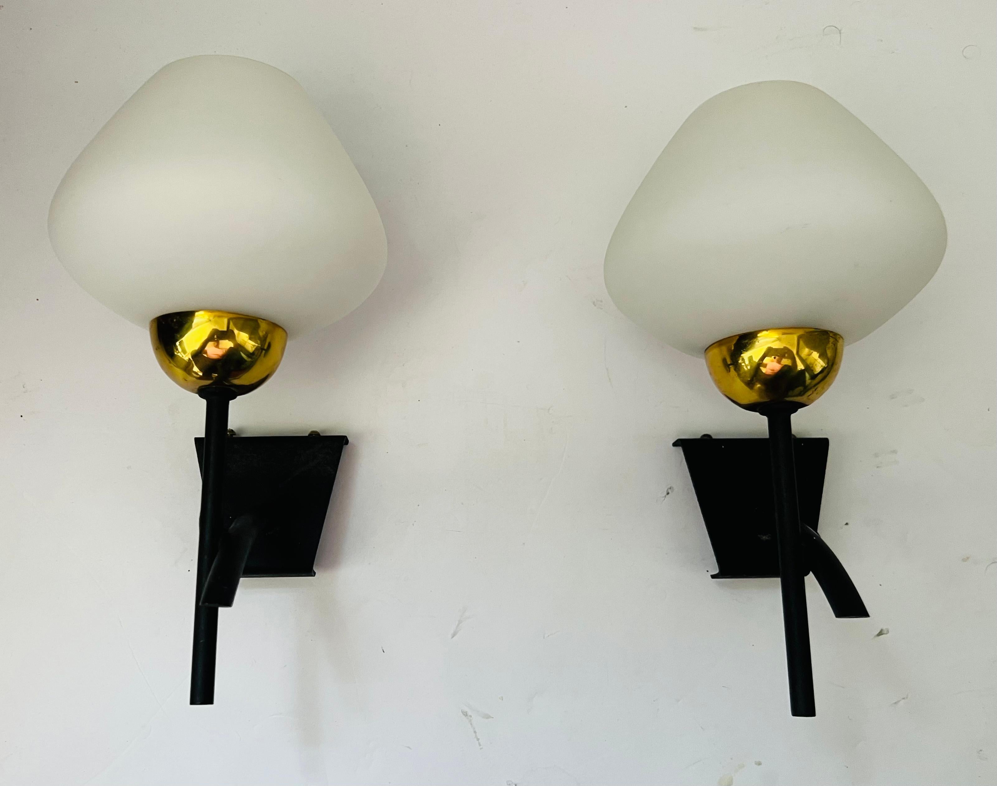 Pair of 1960s French midcentury wall lamps with matte black frames holding white glass shades by Lunel. Rewired.