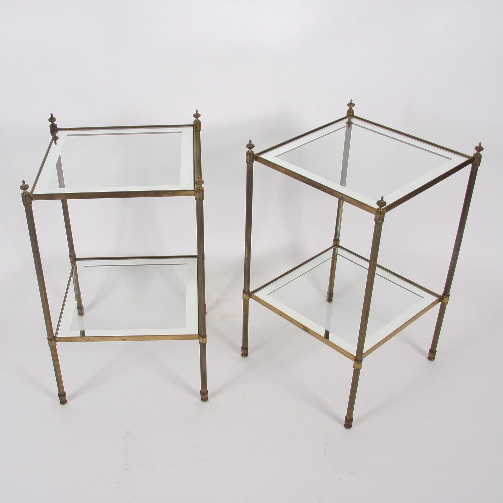 This pair of beautiful two-tier side tables, with mirrored borders, reeded legs and neoclassical-style finials exhibiting stunning patination, dates back to 1960s, France.