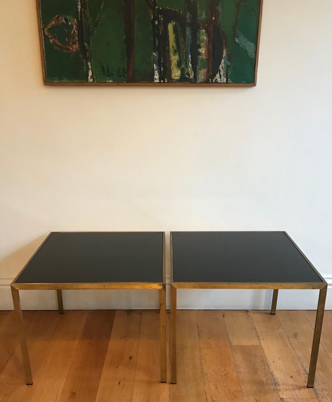 A very elegant pair of gilt metal and black glass side tables. French, circa 1970s. Will complement both a classical and modern interior due to its timeless classic design. The tops have been replaced as the originals were damaged.