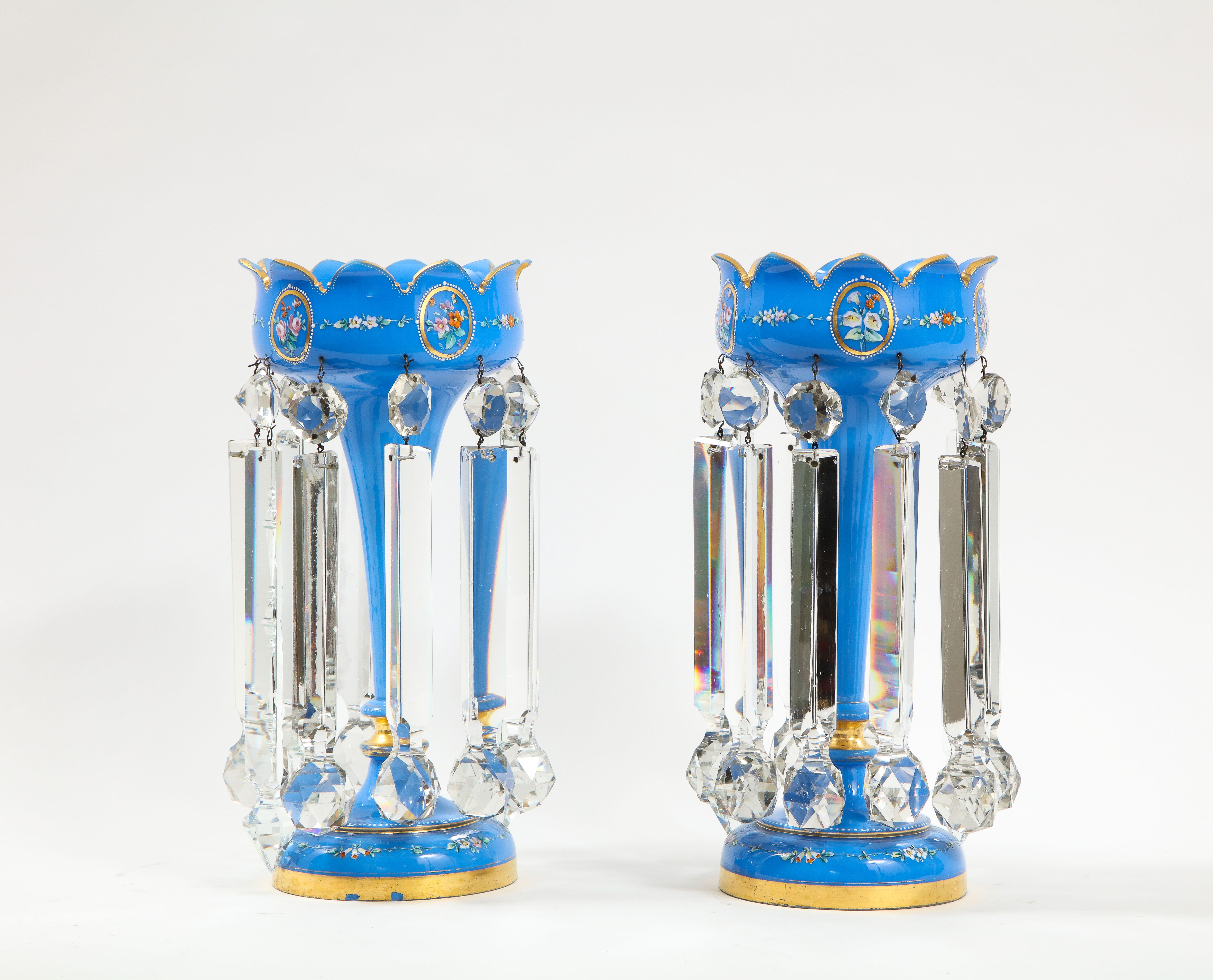 An exquisite pair of French 19th century Louis XVI style blue opalescent crystal tulip form lustre/girandole/candle sticks with hand-painted enamel designs and gilt decoration. Each luster is beautifully hand-carved from the finest blue opalescent