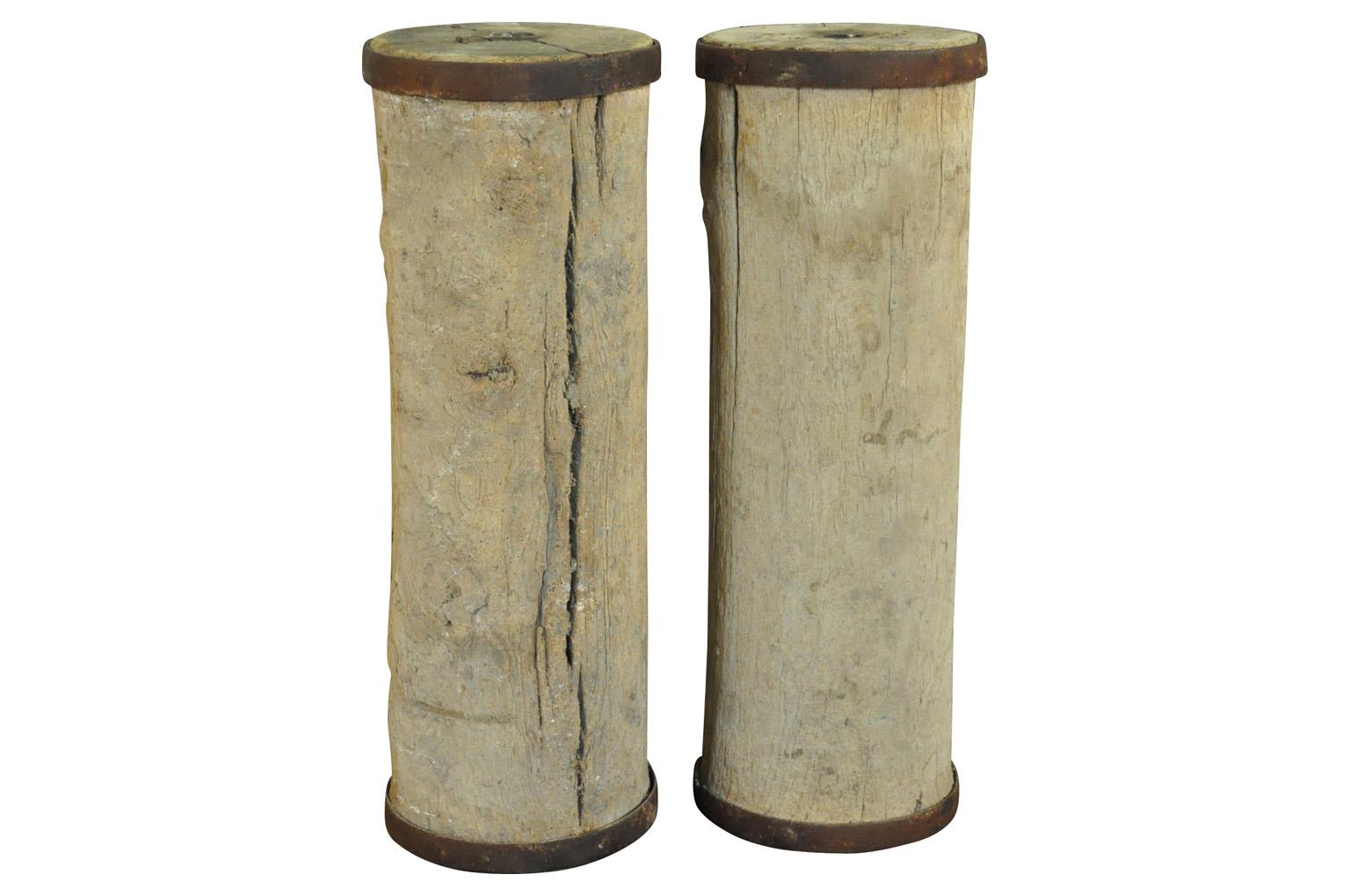 A wonderful pair of early 19th century agricultural cylinders used in the fields - now as terrific pedestals. Solid wood with iron straps.