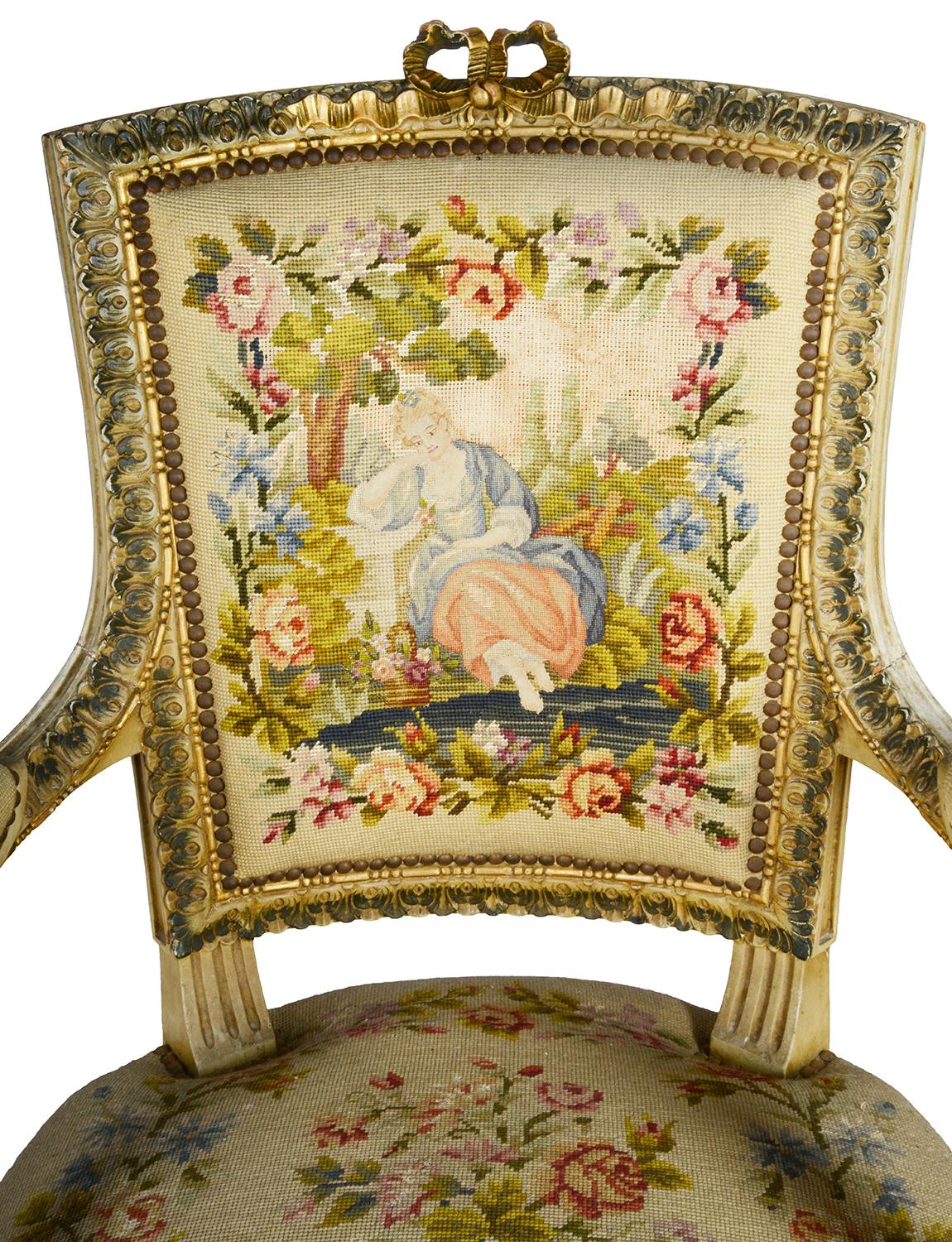A good quality pair of late 19th century French Louis XVI style ivory and gilt decorated armchairs each with wonderful carved scrolling motif, foliate and ribbon decoration. The tapestry seat covers with brightly color scenes of lovers under a tree,