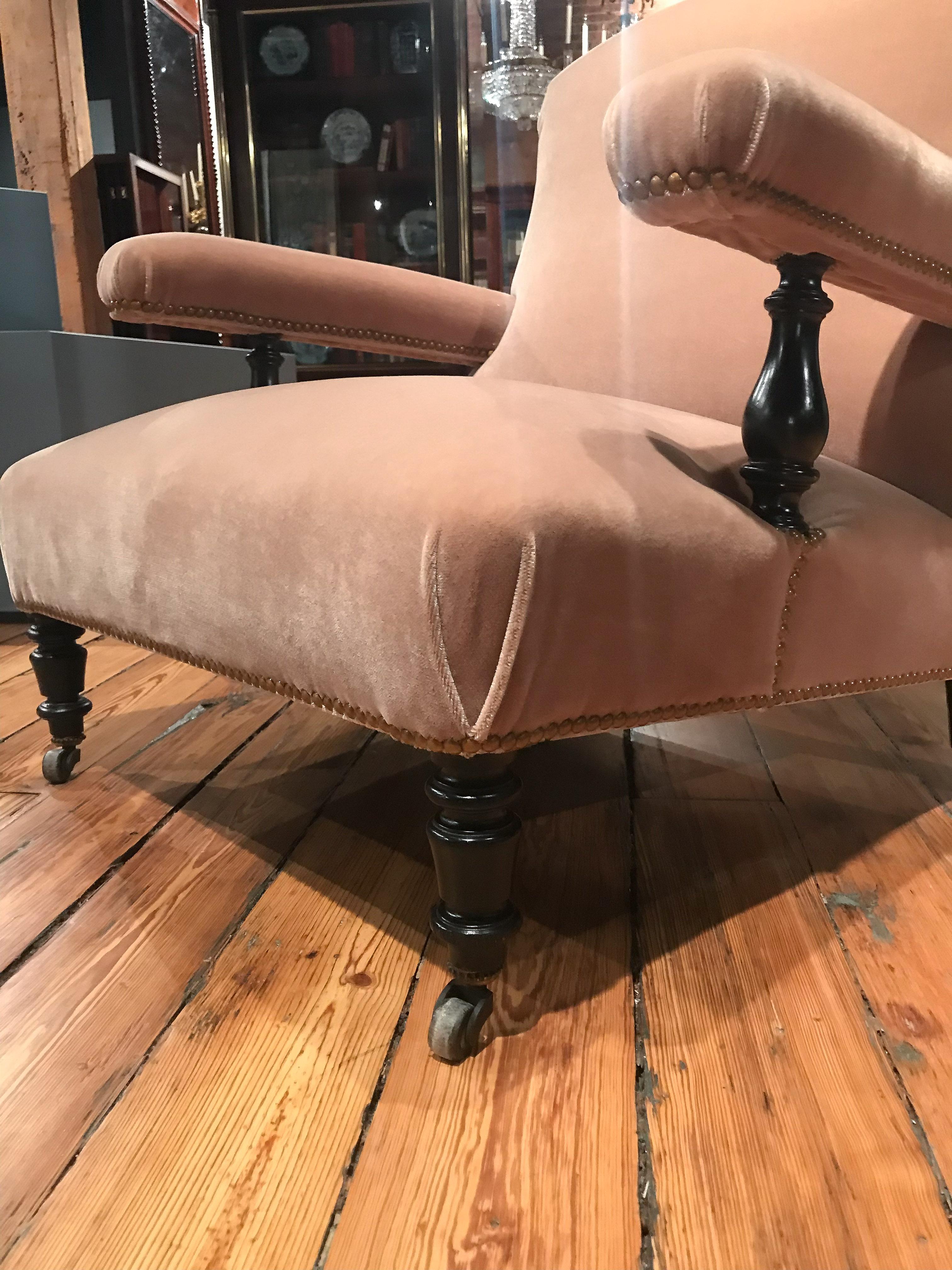 Pair of Napoleon III library chairs with upholstered arms. These chairs have been restored with the exposed frame being ebonized and upholstery done in a rich mohair velvet.
